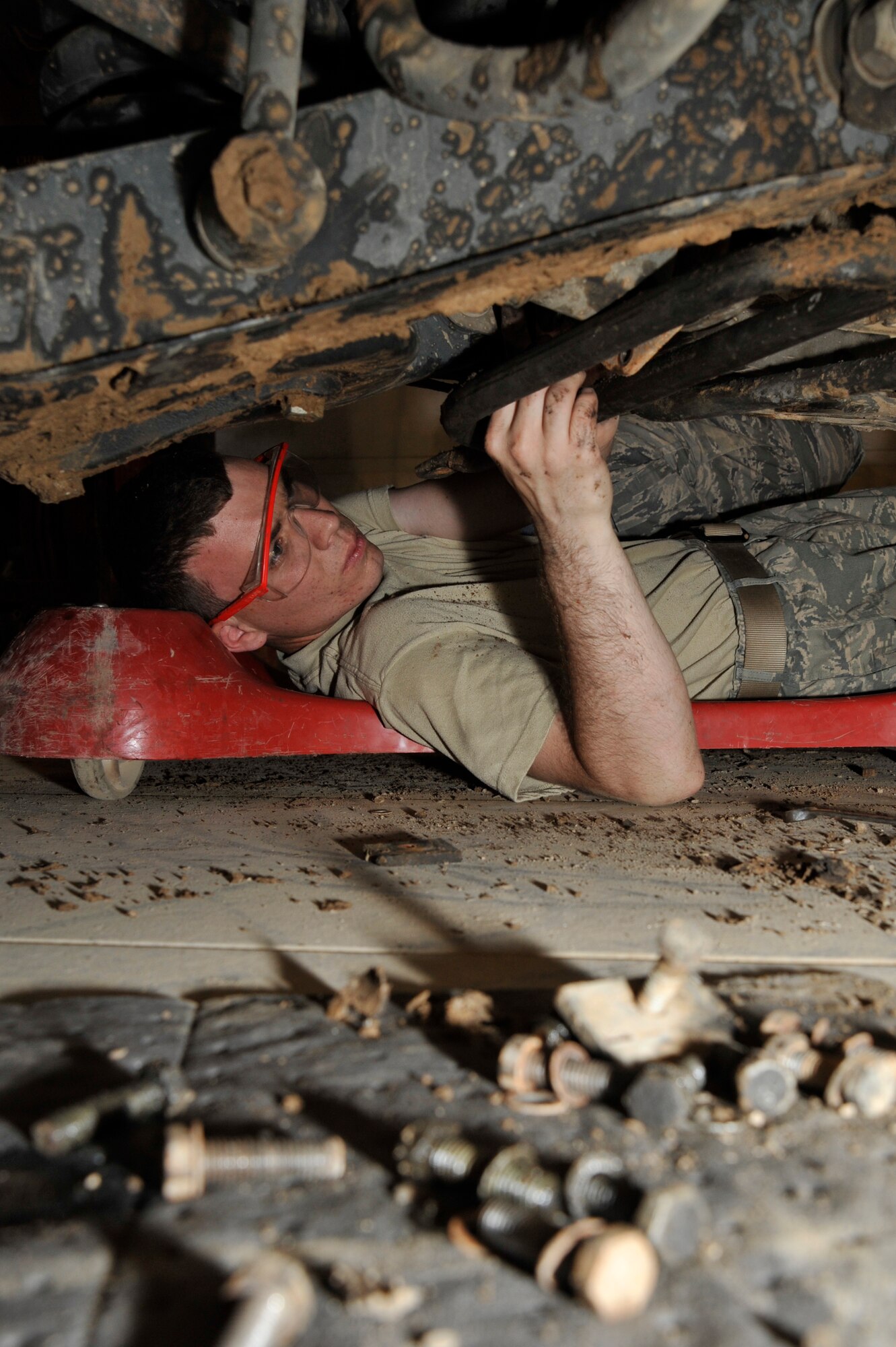 Airman 1st Class Ryan Slifko, 447th Expeditionary Logistics Readiness Squadron, vehicle mechanic, deployed from Whiteman Air Force Base, Mo., removes a brake caliper to install new brake pads on a Humvee June 19, 2010, at Sather Air Base, Iraq. Airman Slifko, from Derby, Kan., joined the Air Force and works in the same career field, and deployed to the same unit as his father, Senior Master Sgt. CJ Slifko, 447th ELRS, vehicle fleet manager. (U.S. Air Force photo by Senior Airman Perry Aston/Released)