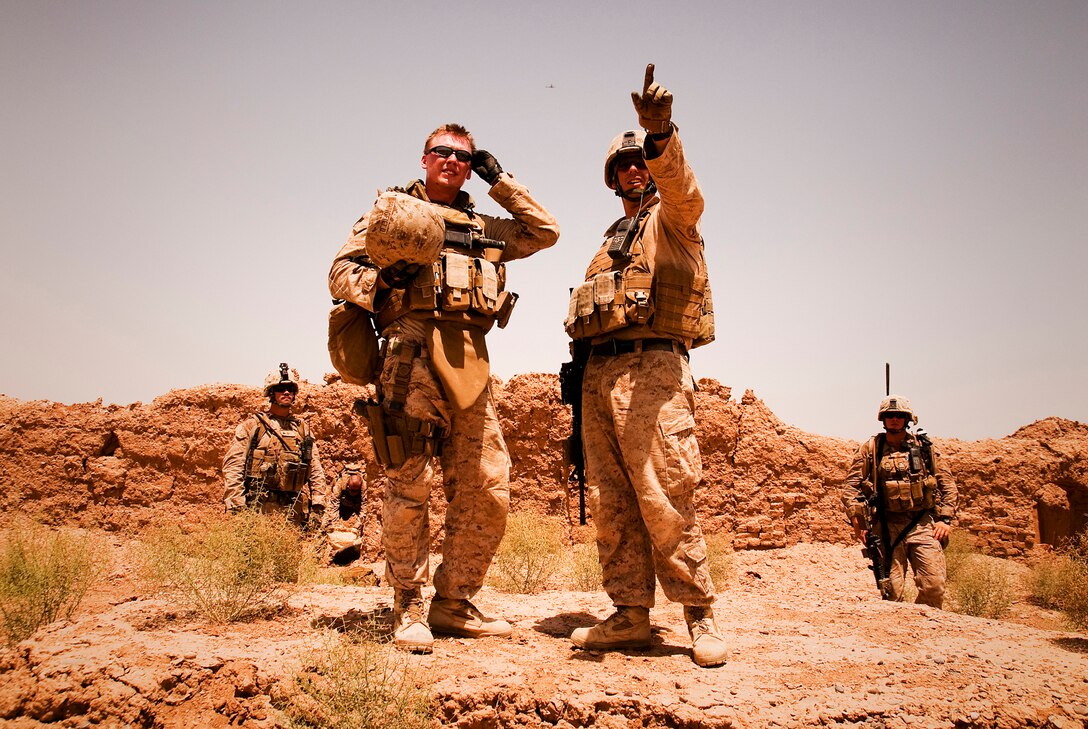 Sgt. James R. Humerick, a squad leader with Lima Company, 3rd Battalion, 3rd Marine Regiment, points out compounds in the area to Sgt. Adam T. Springfield, an explosive ordnance disposal technician with Marine Wing Support Squadron 274, while trying to find the best place to detonate an IED cache found in an abandoned compound by Humerick and his squad during a patrol to the east of their newly established observation post during Operation New Dawn, June 20, 2010. Operation New Dawn is a joint operation between Marine Corps units and the Afghanistan National Army to disrupt enemy forces, which have been using the sparsely populated region between Marjah and Nawa as a safe haven. (Official Marine Corps photo by Sgt. Mark Fayloga)