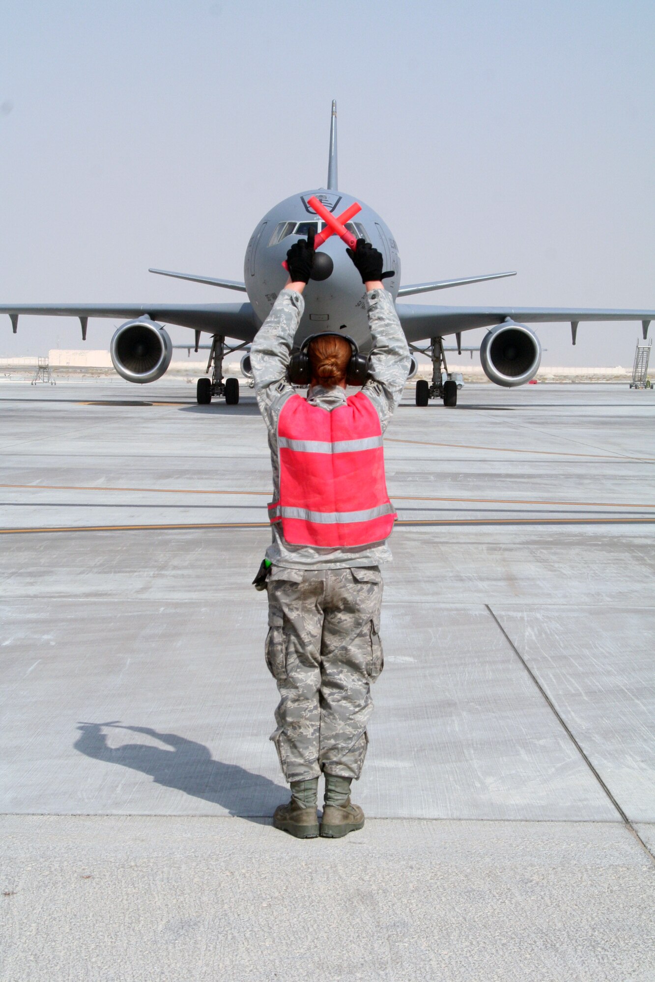 A maintenance Airman from the 380th Expeditionary Aircraft Maintenance Squadron's Extender aircraft maintenance unit provides direction to the flight crew of the KC-10 Extender from the 908th Expeditionary Air Refueling Squadron during flightline operations for the 380th Air Expeditionary Wing at a non-disclosed base in Southwest Asia on June 7, 2010. The 380th AEW supports operations Iraqi Freedom and Enduring Freedom and the Combined Joint Task Force-Horn of Africa. (U.S. Air Force Photo/Master Sgt. Scott T. Sturkol/Released)
