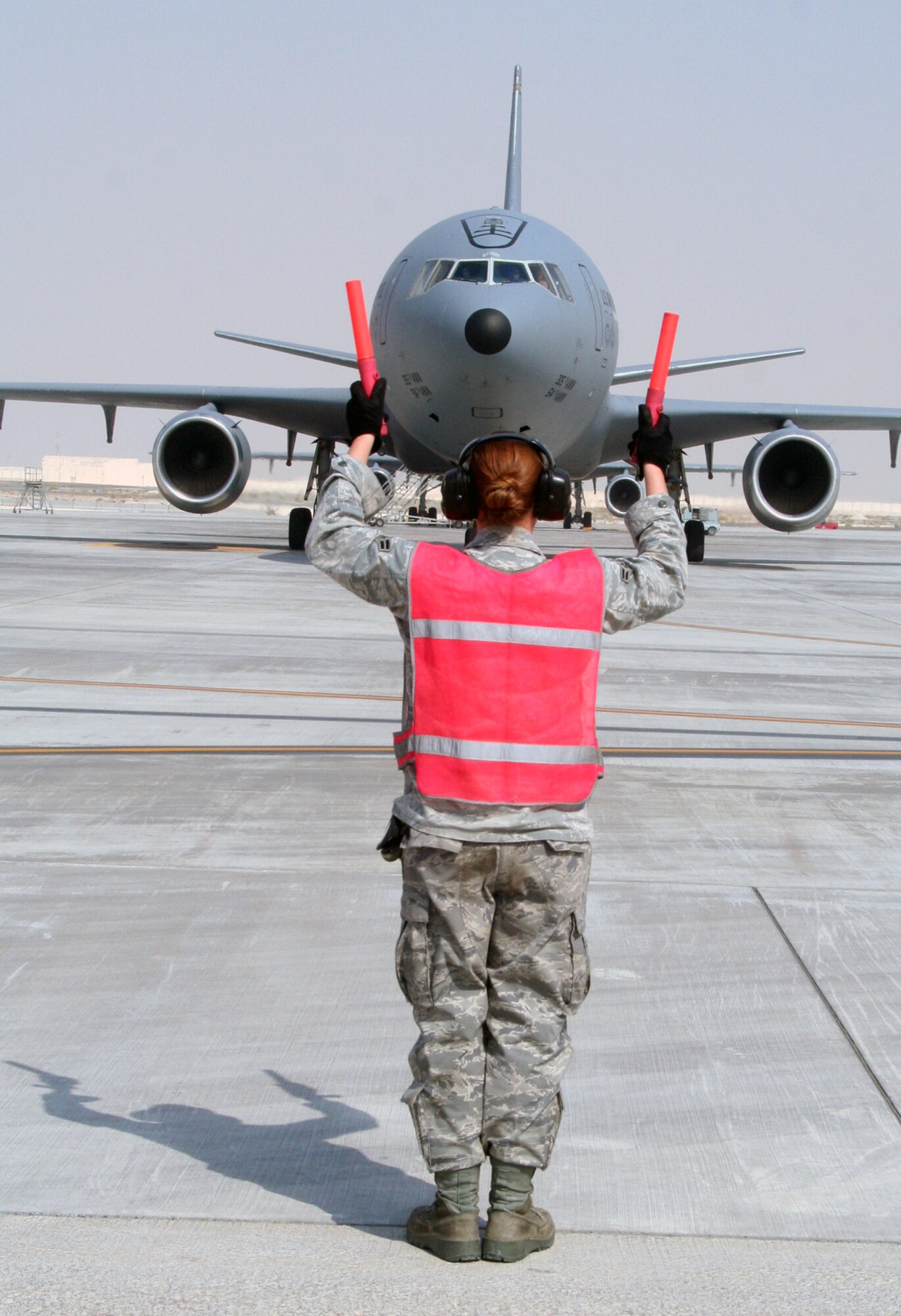 A maintenance Airman from the 380th Expeditionary Aircraft Maintenance Squadron's Extender aircraft maintenance unit provides direction to the flight crew of the KC-10 Extender from the 908th Expeditionary Air Refueling Squadron during flightline operations for the 380th Air Expeditionary Wing at a non-disclosed base in Southwest Asia on June 7, 2010. The 380th AEW supports operations Iraqi Freedom and Enduring Freedom and the Combined Joint Task Force-Horn of Africa. (U.S. Air Force Photo/Master Sgt. Scott T. Sturkol/Released)