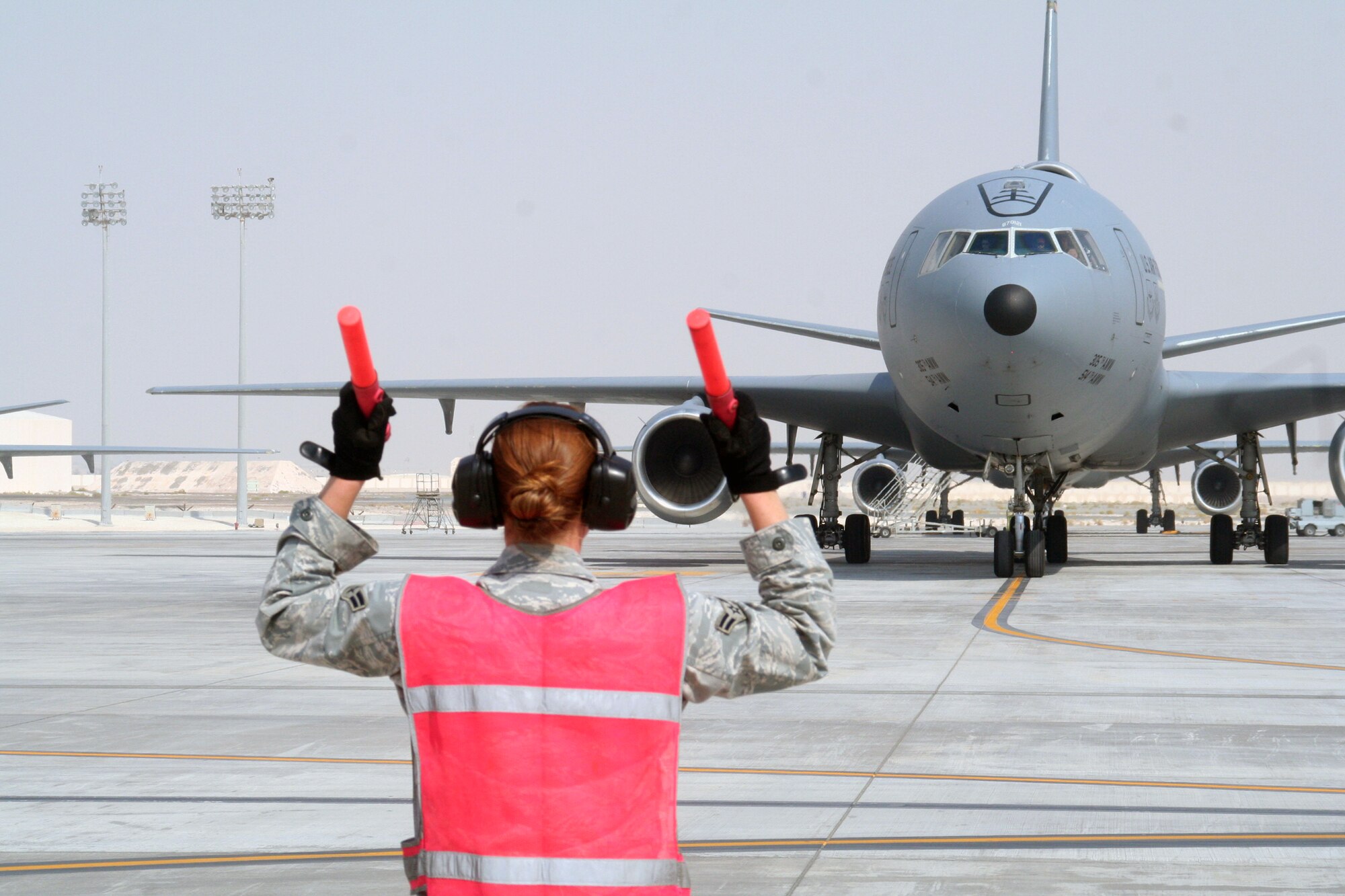 A maintenance Airman from the 380th Expeditionary Aircraft Maintenance Squadron's Extender aircraft maintenance unit provides direction to the flight crew of the KC-10 Extender from the 908th Expeditionary Air Refueling Squadron during flightline operations for the 380th Air Expeditionary Wing at a non-disclosed base in Southwest Asia on June 7, 2010. The 380th AEW supports operations Iraqi Freedom and Enduring Freedom and the Combined Joint Task Force-Horn of Africa. (U.S. Air Force Photo/Master Sgt. Scott T. Sturkol/Released)
