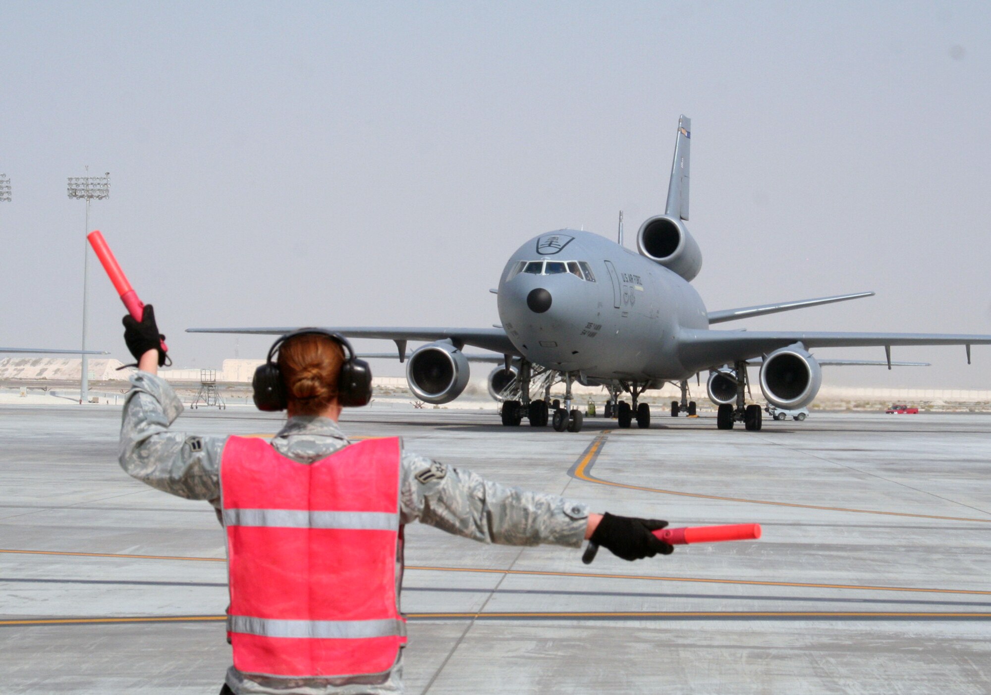 A maintenance Airman from the 380th Expeditionary Aircraft Maintenance Squadron's Extender aircraft maintenance unit provides direction to the flight crew of the KC-10 Extender from the 908th Expeditionary Air Refueling Squadron during flightline operations for the 380th Air Expeditionary Wing at a non-disclosed base in Southwest Asia on June 7, 2010. The 380th AEW supports operations Iraqi Freedom and Enduring Freedom and the Combined Joint Task Force-Horn of Africa. (U.S. Air Force Photo/Master Sgt. Scott T. Sturkol/Released)
