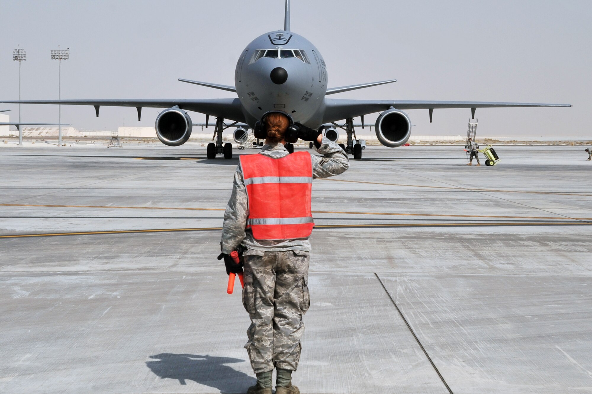 A maintenance Airman from the 380th Expeditionary Aircraft Maintenance Squadron's Extender aircraft maintenance unit provides direction to the flight crew of the KC-10 Extender from the 908th Expeditionary Air Refueling Squadron during flightline operations for the 380th Air Expeditionary Wing at a non-disclosed base in Southwest Asia on June 7, 2010. The 380th AEW supports operations Iraqi Freedom and Enduring Freedom and the Combined Joint Task Force-Horn of Africa. (U.S. Air Force Photo/Master Sgt. Scott T. Sturkol/Released)