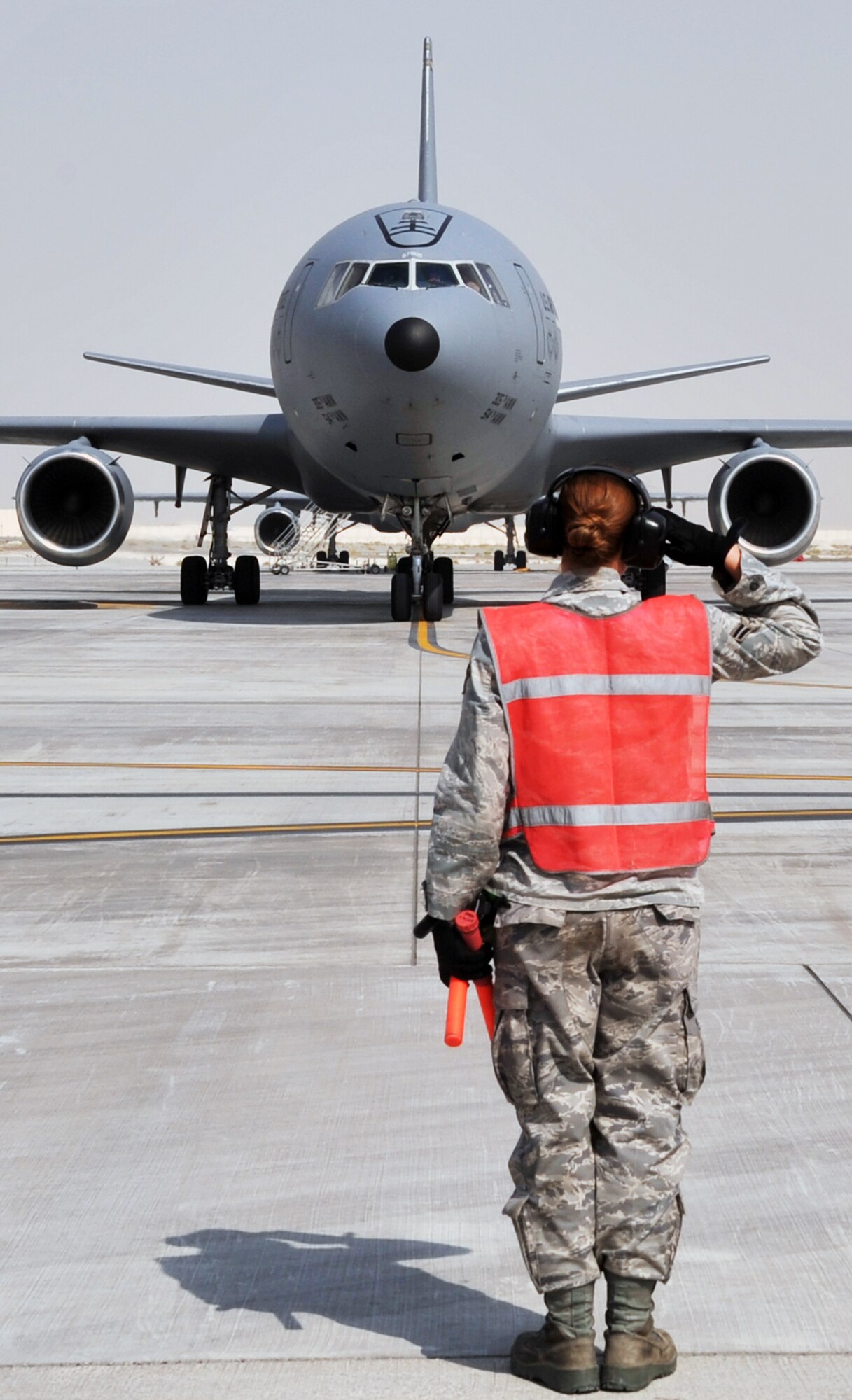 A maintenance Airman from the 380th Expeditionary Aircraft Maintenance Squadron's Extender aircraft maintenance unit provides direction to the flight crew of the KC-10 Extender from the 908th Expeditionary Air Refueling Squadron during flightline operations for the 380th Air Expeditionary Wing at a non-disclosed base in Southwest Asia on June 7, 2010. The 380th AEW supports operations Iraqi Freedom and Enduring Freedom and the Combined Joint Task Force-Horn of Africa. (U.S. Air Force Photo/Master Sgt. Scott T. Sturkol/Released)