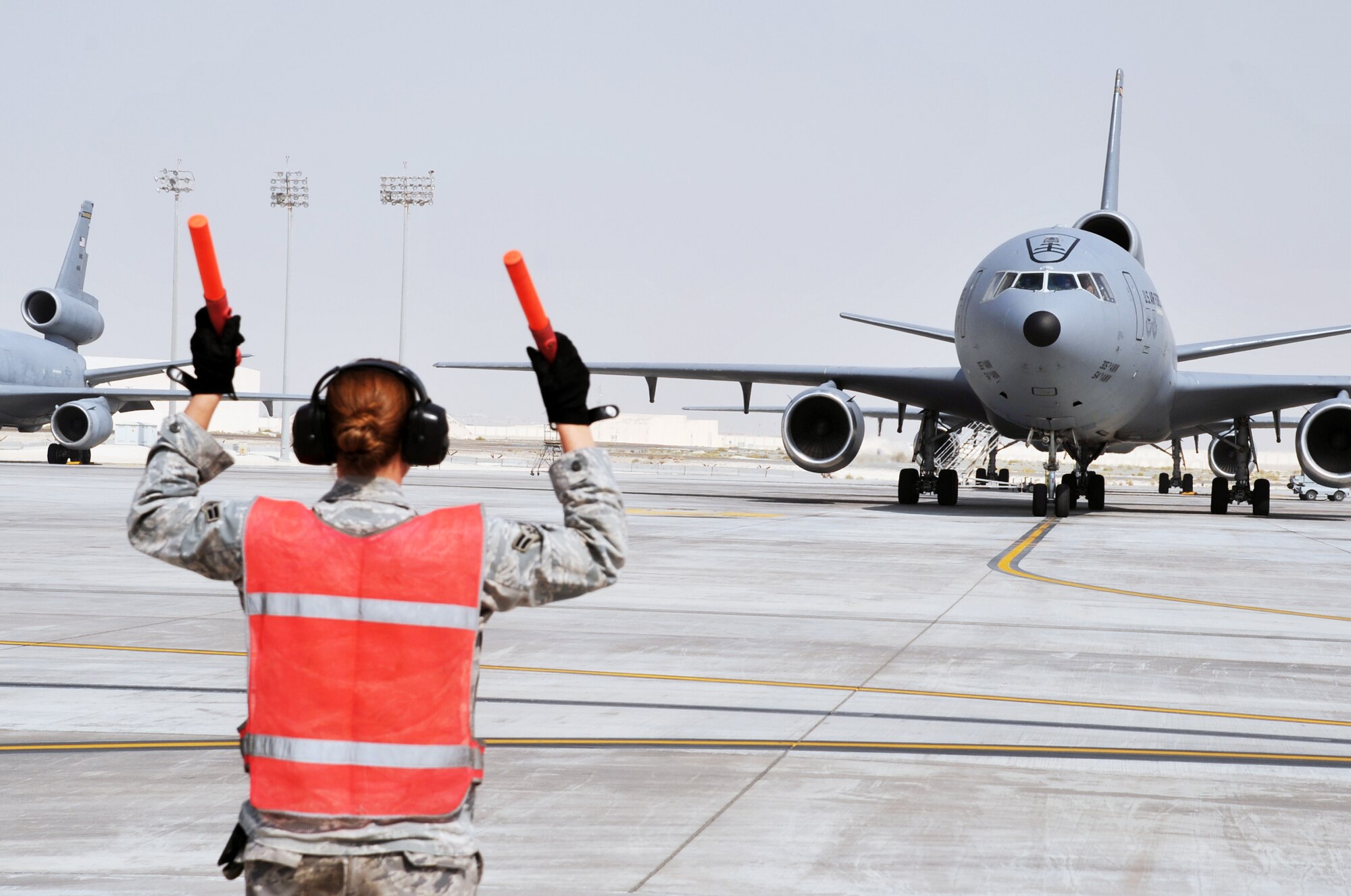 A maintenance Airman from the 380th Expeditionary Aircraft Maintenance Squadron's Extender aircraft maintenance unit provides direction to the flight crew of the KC-10 Extender from the 908th Expeditionary Air Refueling Squadron during flightline operations for the 380th Air Expeditionary Wing at a non-disclosed base in Southwest Asia on June 7, 2010. The 380th AEW supports operations Iraqi Freedom and Enduring Freedom and the Combined Joint Task Force-Horn of Africa. (U.S. Air Force Photo/Master Sgt. Scott T. Sturkol/Released)
