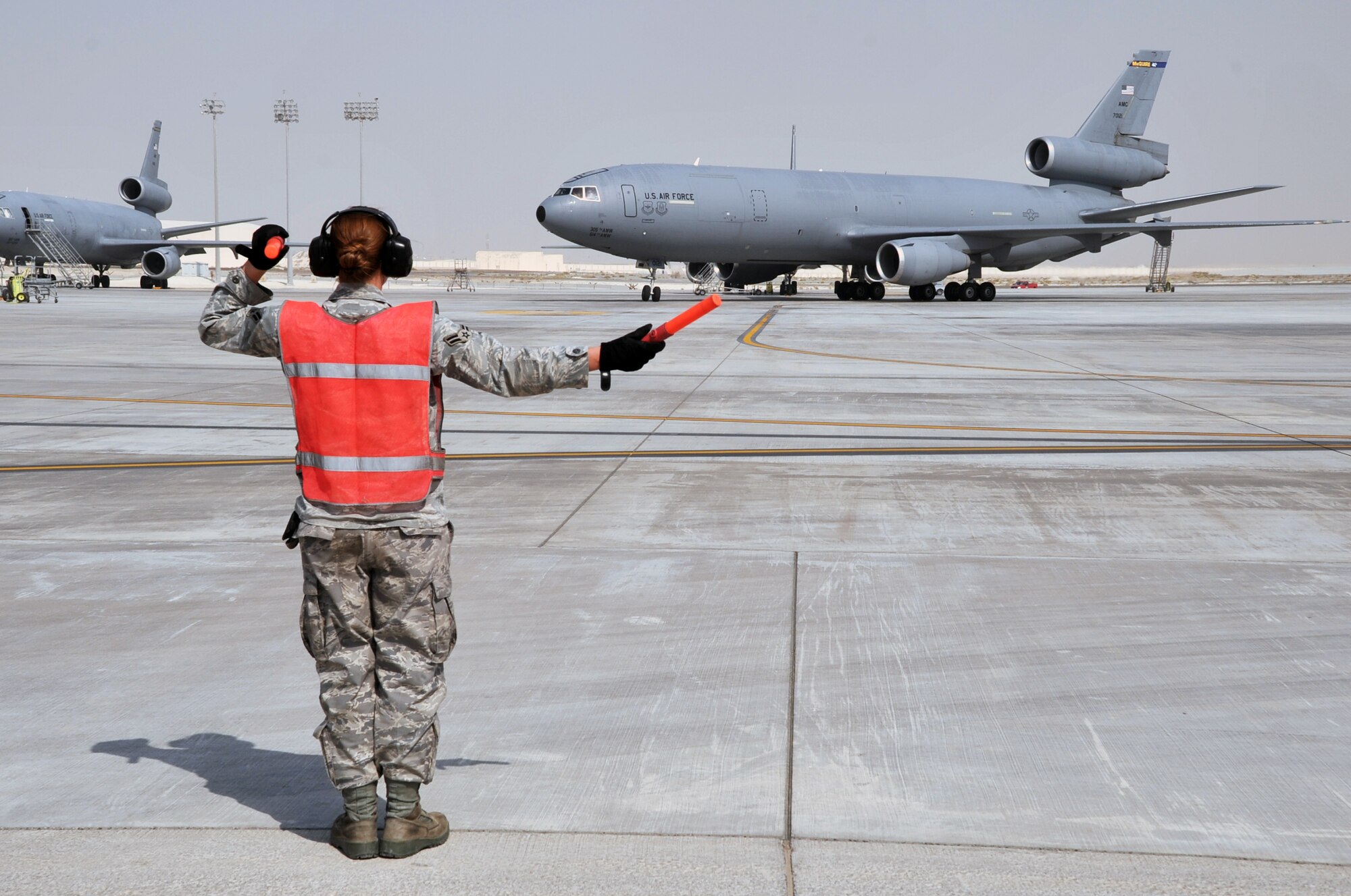 A maintenance Airman from the 380th Expeditionary Aircraft Maintenance Squadron's Extender aircraft maintenance unit provides direction to the flight crew of the KC-10 Extender from the 908th Expeditionary Air Refueling Squadron during flightline operations for the 380th Air Expeditionary Wing at a non-disclosed base in Southwest Asia on June 7, 2010. The 380th AEW supports operations Iraqi Freedom and Enduring Freedom and the Combined Joint Task Force-Horn of Africa. (U.S. Air Force Photo/Master Sgt. Scott T. Sturkol/Released)