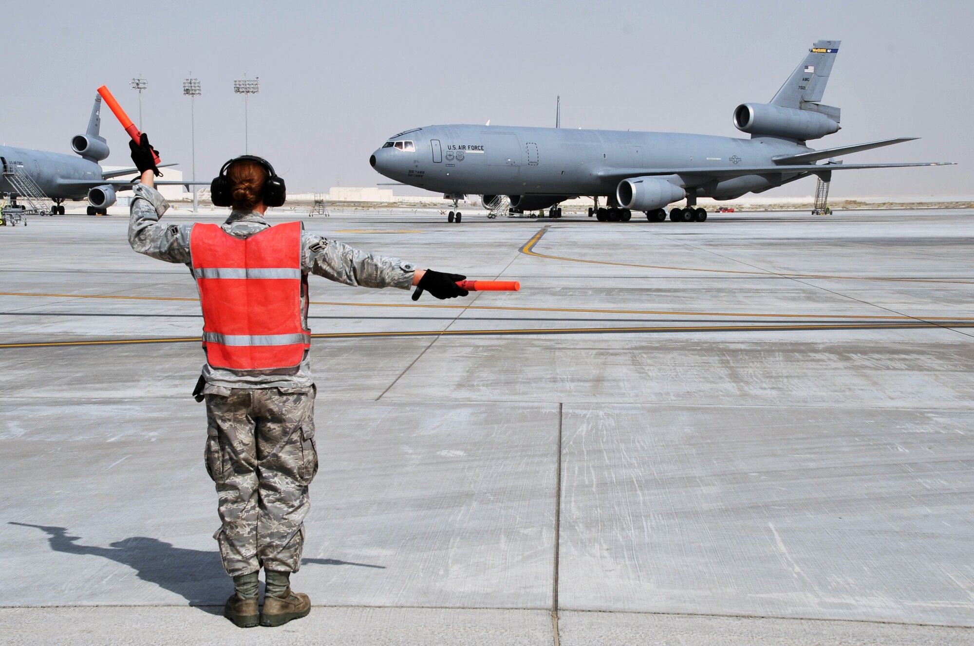 A maintenance Airman from the 380th Expeditionary Aircraft Maintenance Squadron's Extender aircraft maintenance unit provides direction to the flight crew of the KC-10 Extender from the 908th Expeditionary Air Refueling Squadron during flightline operations for the 380th Air Expeditionary Wing at a non-disclosed base in Southwest Asia on June 7, 2010. The 380th AEW supports operations Iraqi Freedom and Enduring Freedom and the Combined Joint Task Force-Horn of Africa. (U.S. Air Force Photo/Master Sgt. Scott T. Sturkol/Released)