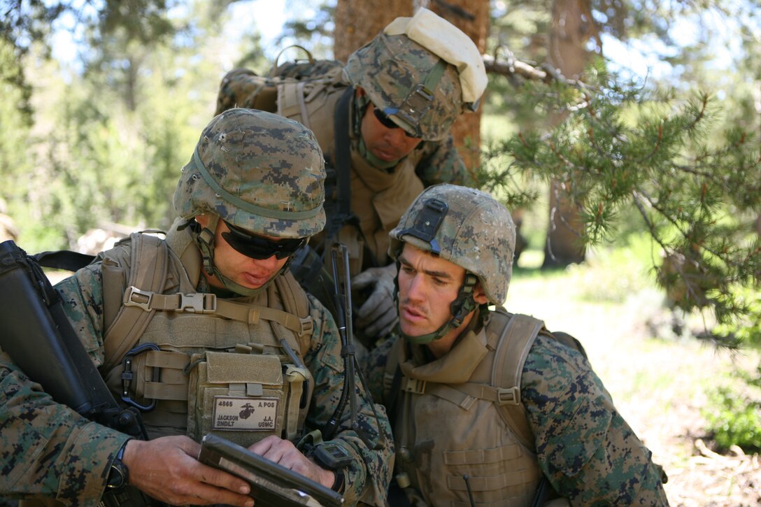 Lance Cpl.'s Benani Acevado, rifleman, (center) and Malcolm Miller, team leader, (left) help 2nd Lt. Jake Jackson, acting 3rd platoon commander (center) study a map and plan the next route for their patrol.