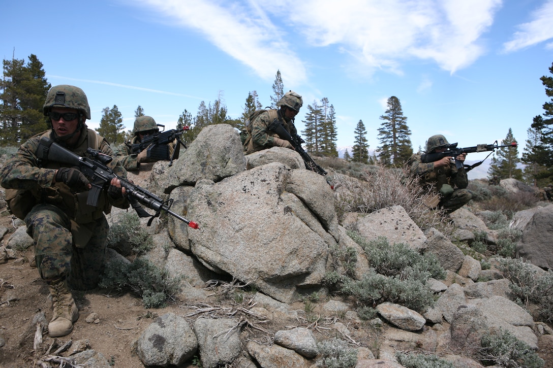 Marines with 1st Battalion, 25th Marine Regiment take covers behind rocks and prepare to return fire after being ambushed by a mock enemy force.