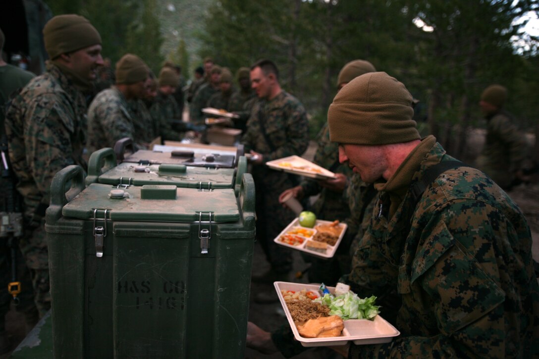 Marines with Company A, 1st Battalion, 25th Marine Regiment line up to receive hot chow after finishing a day of training in the field.