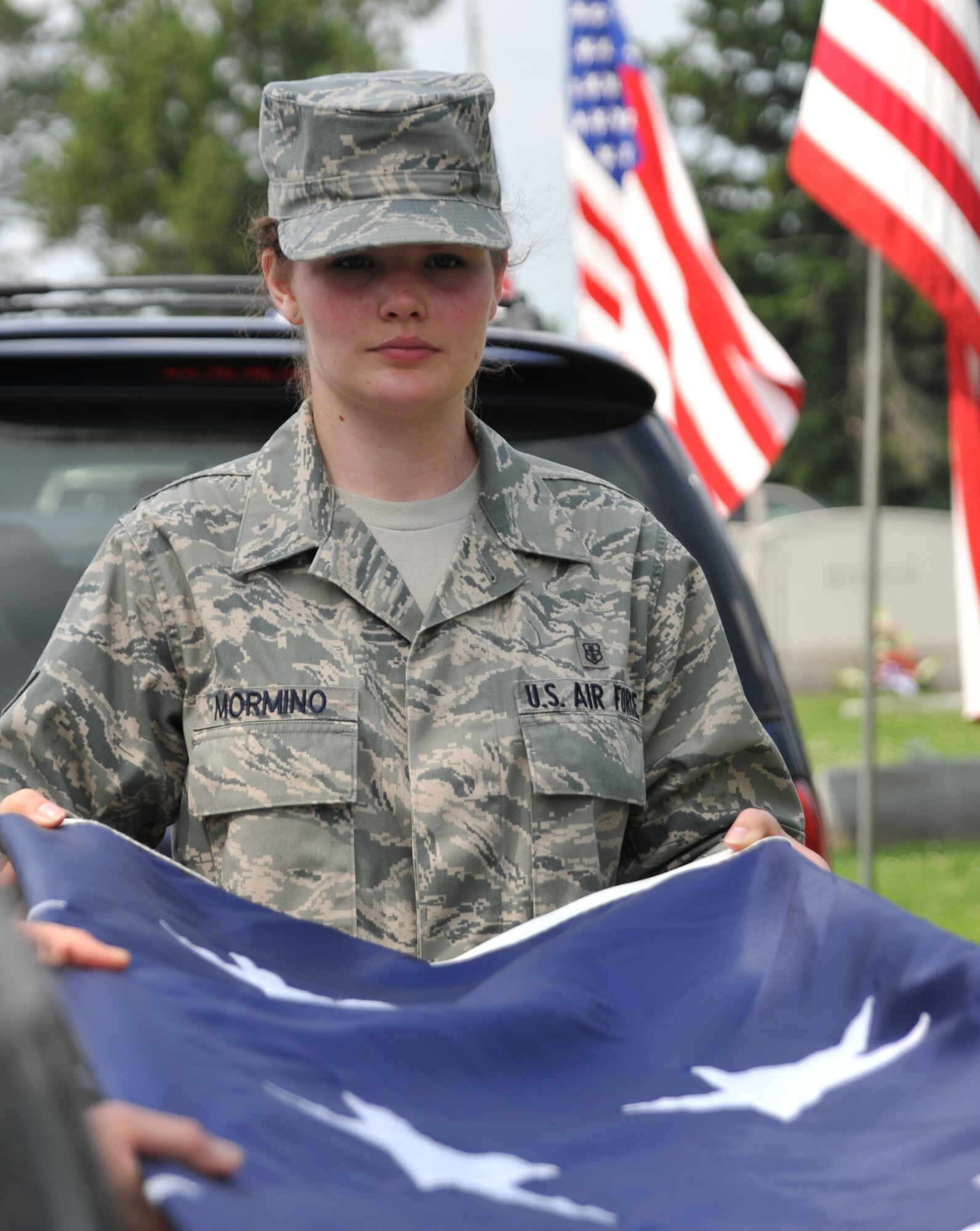 Senior Airman Emily Mormino, 932nd Aeromedical Evacuation Squadron, gently helps fold the wing's American flag downtown recently.  The unit is preparing to once again carry the bigger 30 foot by 60 foot flag in the Veiled Prophet parade on July 3.  (U.S. Air Force photo/Tech. Sgt. Chris Parr)