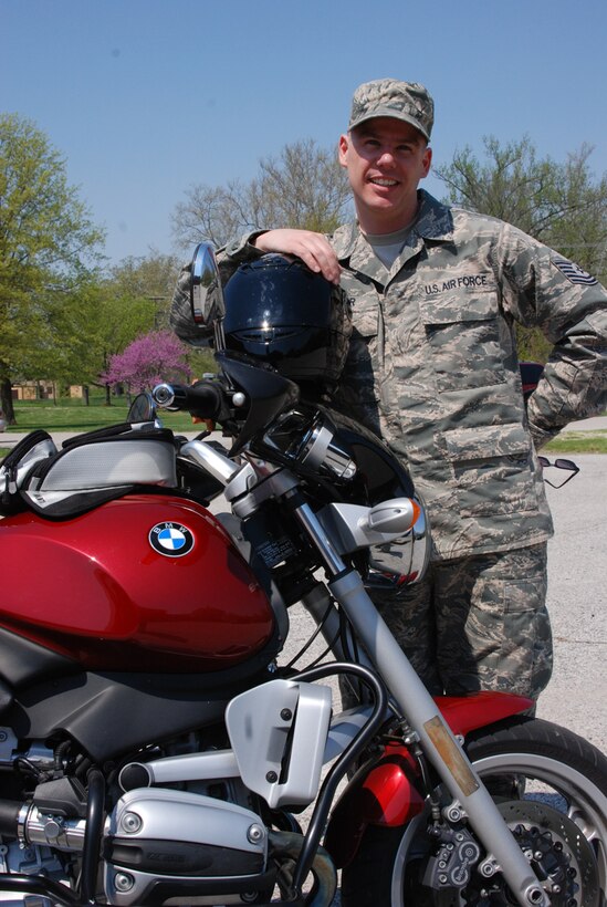 Tech. Sgt. Chris Parr, a reservist with the 932nd Airlift Wing, cradles the most important piece of equipment to him as a bike rider:  his helmet!  He reminds other motorcycle enthusiasts to wear a helmet, gloves, protective contrasting jacket and pants with boots.  (U.S. Air Force photo/Maj. Stan Paregien)