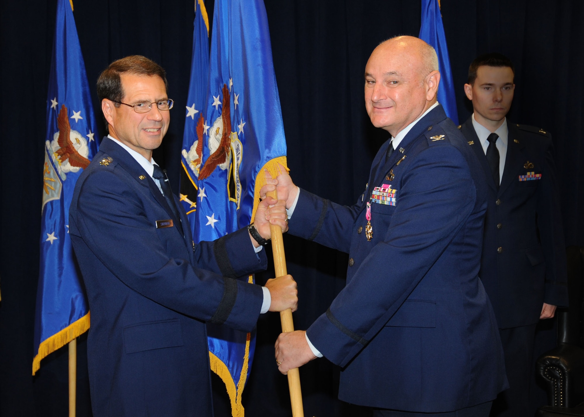Colonel David Madden (right), Global Positioning Systems Wing, relinquishes command of the wing at a ceremony, June 18. The colonel is retiring from the Air Force but not leaving the Space and Missile Systems Center. As a civilian, he will assume command of the Military Satellite Communications Systems Wing next month.  (Photo by Lou Hernandez)