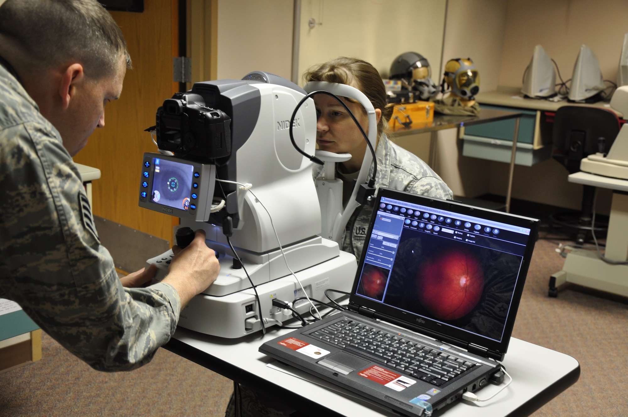 Staff Sgts. Michael Mayes (left) and Monique Hudson, 383rd Training Squadron instructors, test a digital non-mydriatic device. Students are trained on this instrument to take photos of the inside of the eye. (U.S. Air Force photo/ Airman 1st Class Valerie Hosea)
