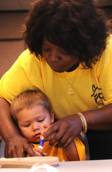 MOODY AIR FORCE BASE, Ga. -- Gennatt Williams, retired military spouse, helps Aiden Bone, son of Staff Sgts. Michael and Crystal Bone, color a sarcophagus during Vacation Bible School here June 16. The theme for this year was Egyptian. (U.S. Air Force photo by Airman 1st Class Benjamin Wiseman/RELEASED)
