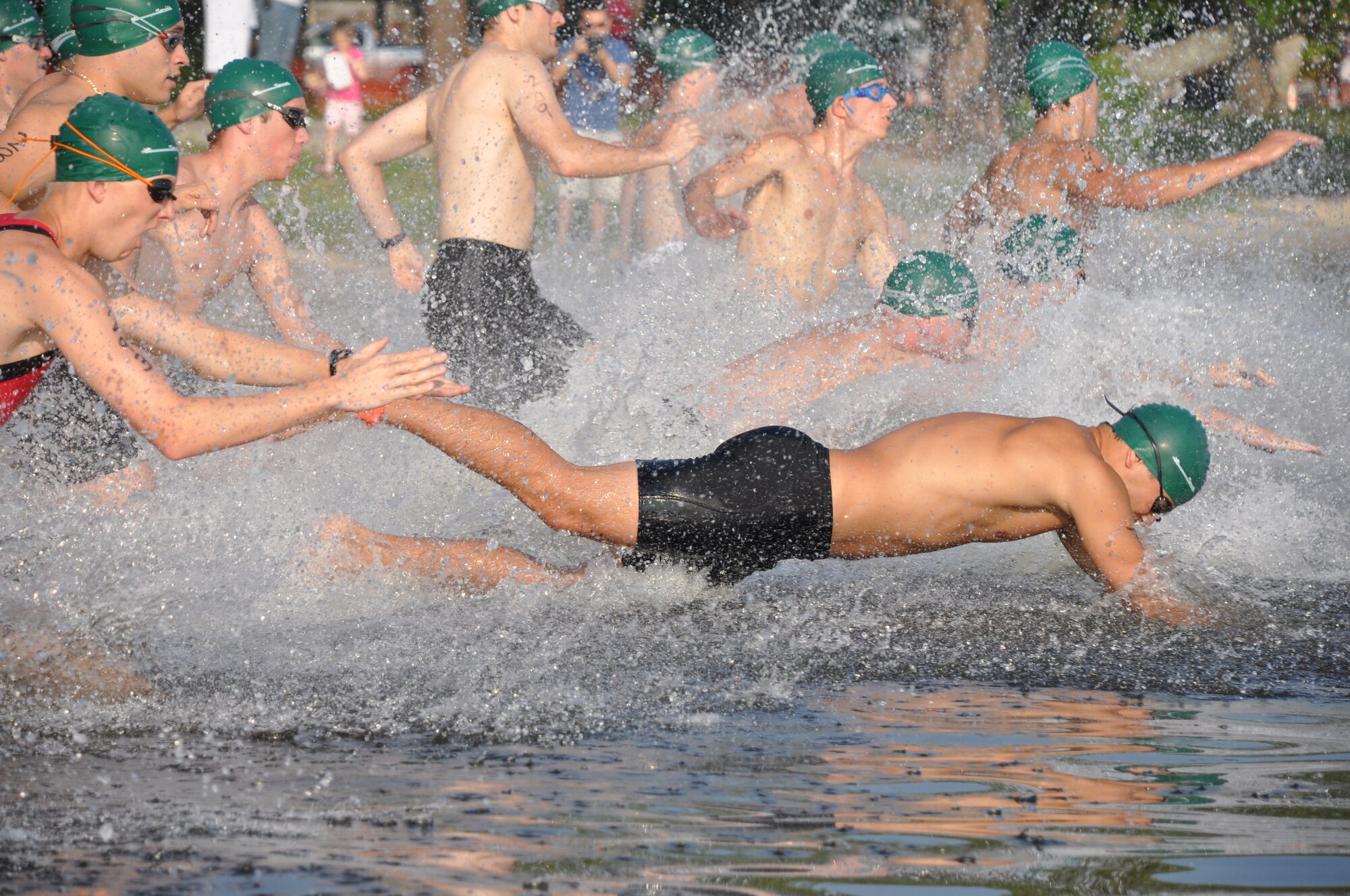 EGLIN AIR FORCE BASE, Fla. -- The green team dives into the 200-meter swim during Eglin's 11th annual My First Tri June 19. There were 337 athletes in the event and 181 of them participated for the first time. Each individual completed a 200-meter swim, an 8-mile bike ride and a 2.5 mile run. Everyone received a medal and all results are listed on www.eventtiming.com. (Air Force photo/Chrissy Cuttita)