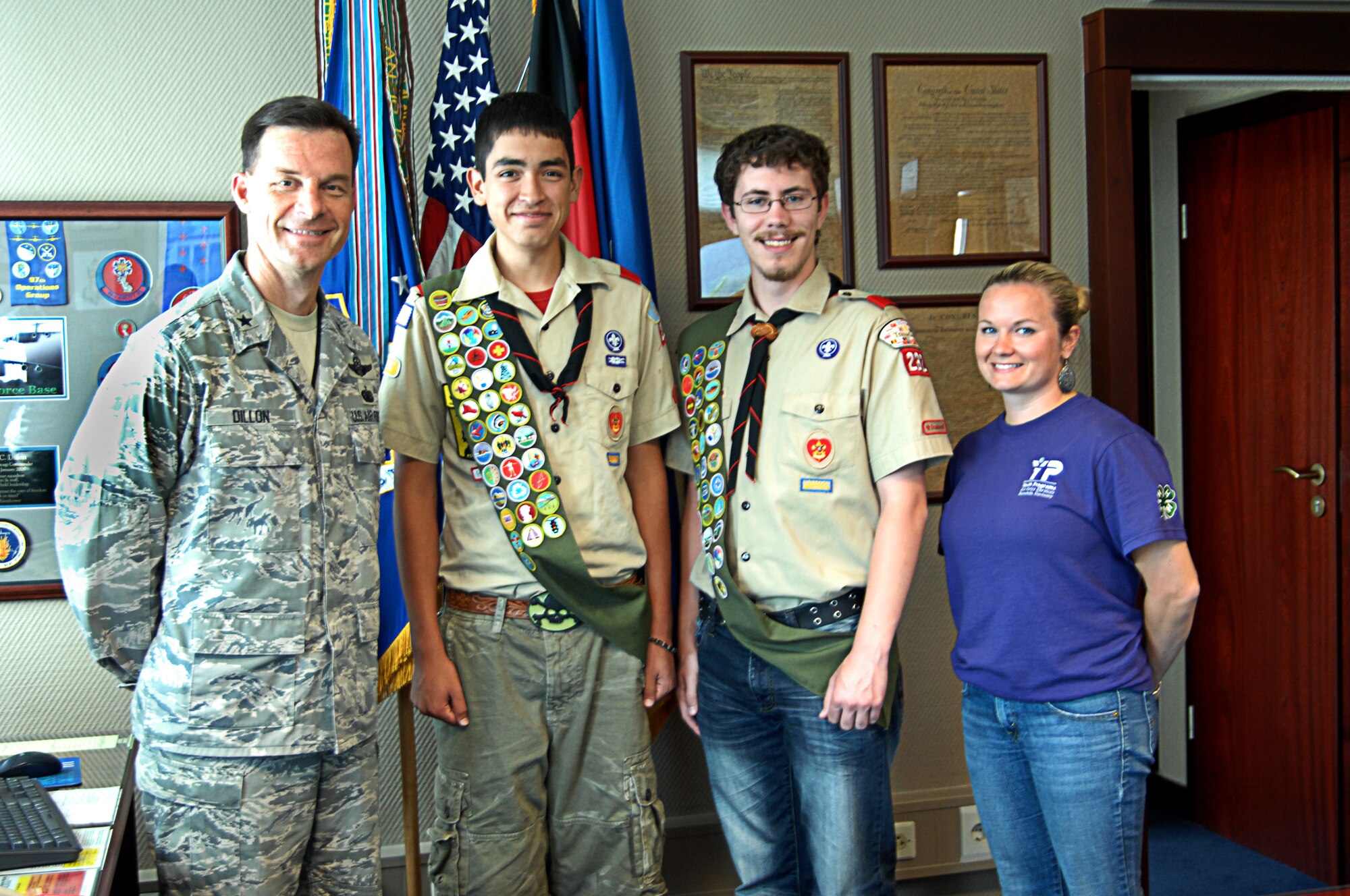 Brooke Sands, Sports Director with Ramstein Youth Programs, takes a photo with Brig. Gen. Dillon and Eagle Scouts David Ladnier and Quinton Leith during a coining ceremony on June 5, 2010. Sands came up with the initial idea for Eagle Scouts to cleanup Donnelly Park. The scouts invested a total of 206 combined man hours managing, organizing and cleaning the park. (U.S. Air Force Airman 1st Class Ciara M. Travis)