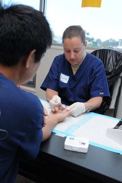 Staff Sgt. Katie Duff, a medical technician with the 193rd Special Operations Wing's Medical Group out of Middletown, Pa., takes blood from the finger of Eli Ishimoto to test his glucose and cholestrol. Duff and other members of the 193rd Medical Group provided free health screenings atthe Hawaii County Office of Aging in Hilo, Hawaii, on June 14th, 2010. Members of the 193rd Medical Group are in Hilo for Medical Innovative Readiness Training.