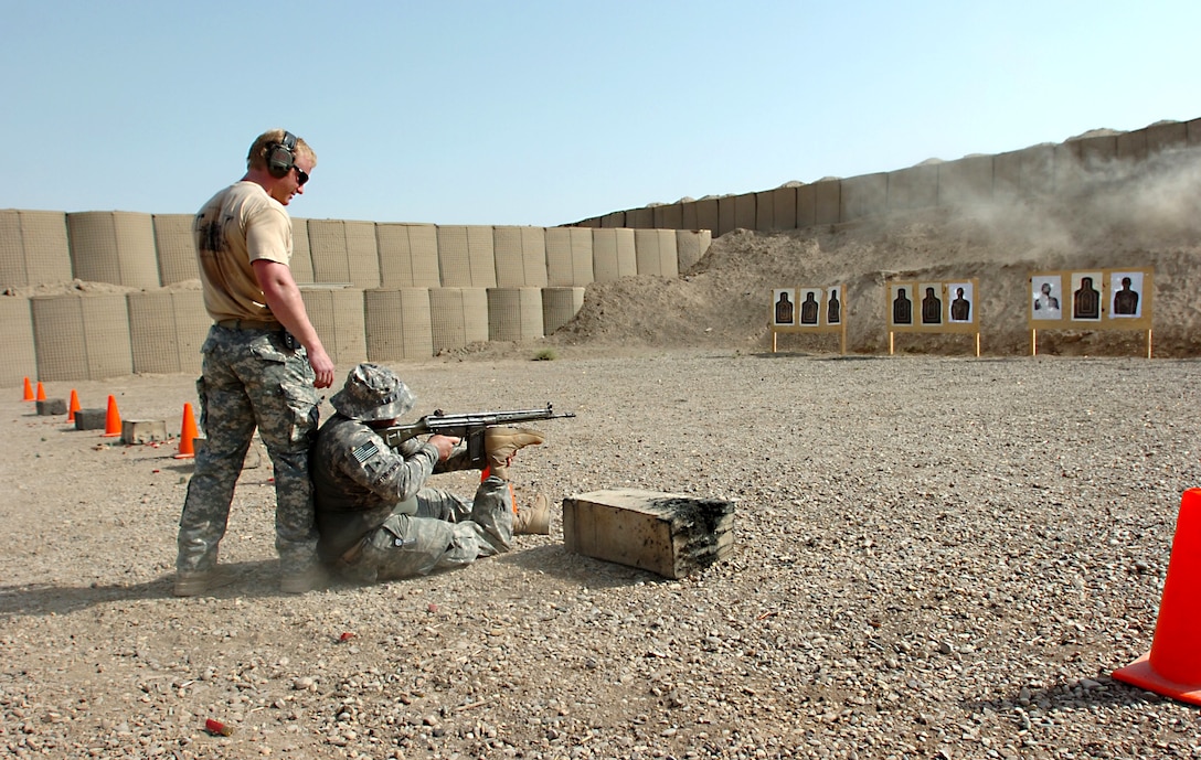 U.S. Army Sgt. Andy Butterworth, sitting, uses his prosthetic leg to steady his rifle while shooting at a target on an Iraqi range near Baghdad, June 16, 2010. U.S. Army Sgt. 1st Class John Hasenbein, assigned to Company A, 1st, Battalion, 5th Special Forces Group, provides support. Butterwork was last assigned to the 1st Battalion, 120th Infantry Regiment.