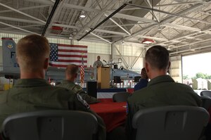 LANGLEY AIR FORCE BASE, Va. -- 1st Operations Group leaders look on as Capt. Lee Stewart, 1st Aircraft Maintenance Squadron, delivers the opening address at the 71st Fighter Squadron open house in the squadron hangar June 18. The festivities included awards presentations, free food and visits from distinguished alumni in celebration of the impending squadron inactivation. (U.S. Air Force photo/Airman 1st Class Jason J. Brown)