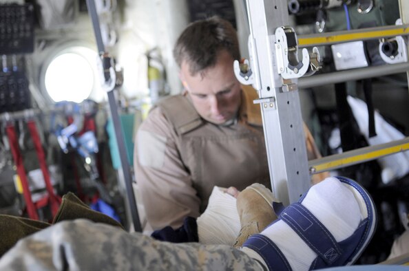 Tech. Sgt. Thomas Grantland secures the litter onto a C-130J Hercules after loading a patient June 9 at Kandahar Airfield, Afghanistan.  Sergeant Grantland is assigned to the 451st Expeditionary Aeromedical Evacuation Squadron. (U.S. Air Force photo/Senior Airman Nancy Hooks)