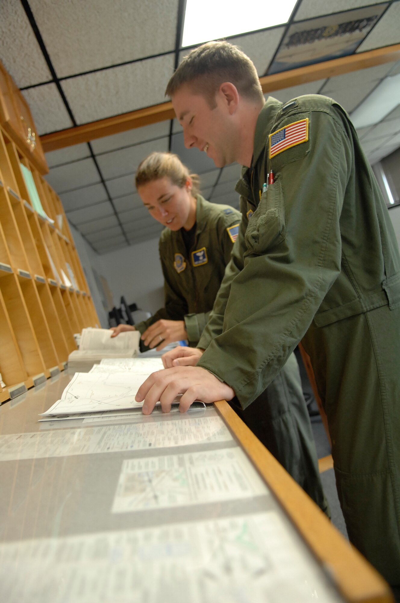 ANDREWS AIR FORCE BASE, Md. -- Pilots Capt. Mary Ashley Thomer and 2nd Lt. Collin Hartwell, both from the 457th Airlift Squadron, go over maps before taking flight. (U.S Air Force photo/ Airman 1st Class Amber Kelly-Herard)