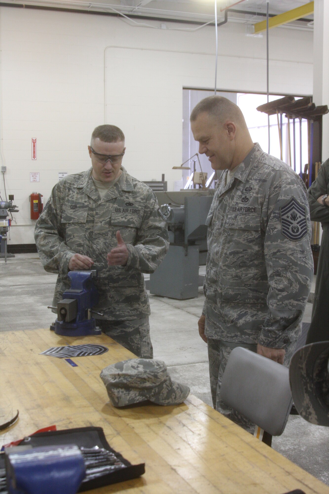 WRIGHT-PATTERSON AIR FORCE BASE, Ohio - Master Sgt. Jason Cox, 445th Maintenance Squadron, shows Chief Master Sgt. of the Air Force James A. Roy how they used a  laser machine to manufacture the magnetic rank signs they were giving him during his visit to the wing June 11. The engraved name will be placed on the CMSAF board at the 88th Air Base Wing Airman Leadership School. The Chief was visiting Wright-Patterson Air Force Base as part of the “Corona Top” summit held at the base. (U.S. Air Force photo/Stacy Vaughn)