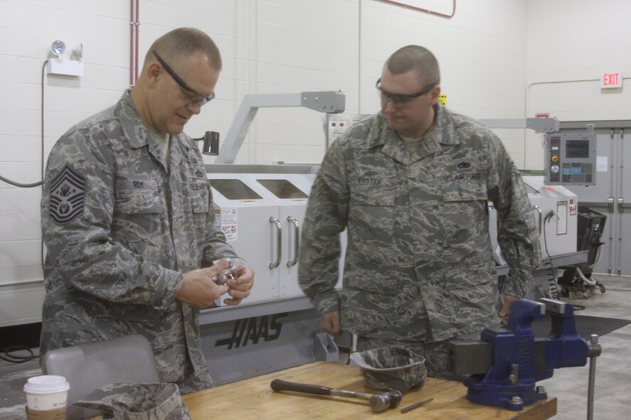 WRIGHT-PATTERSON AIR FORCE BASE, Ohio – Staff Sgt. Michael Foster, 445th Maintenance Squadron, shows Chief Master Sgt. of the Air Force James A. Roy some of the tools used in the Metals Technology shop during the Chief’s visit to the wing June 11. The Chief was visiting Wright-Patterson Air Force Base as part of the “Corona Top” summit held at the base. (U.S. Air Force photo/Stacy Vaughn)