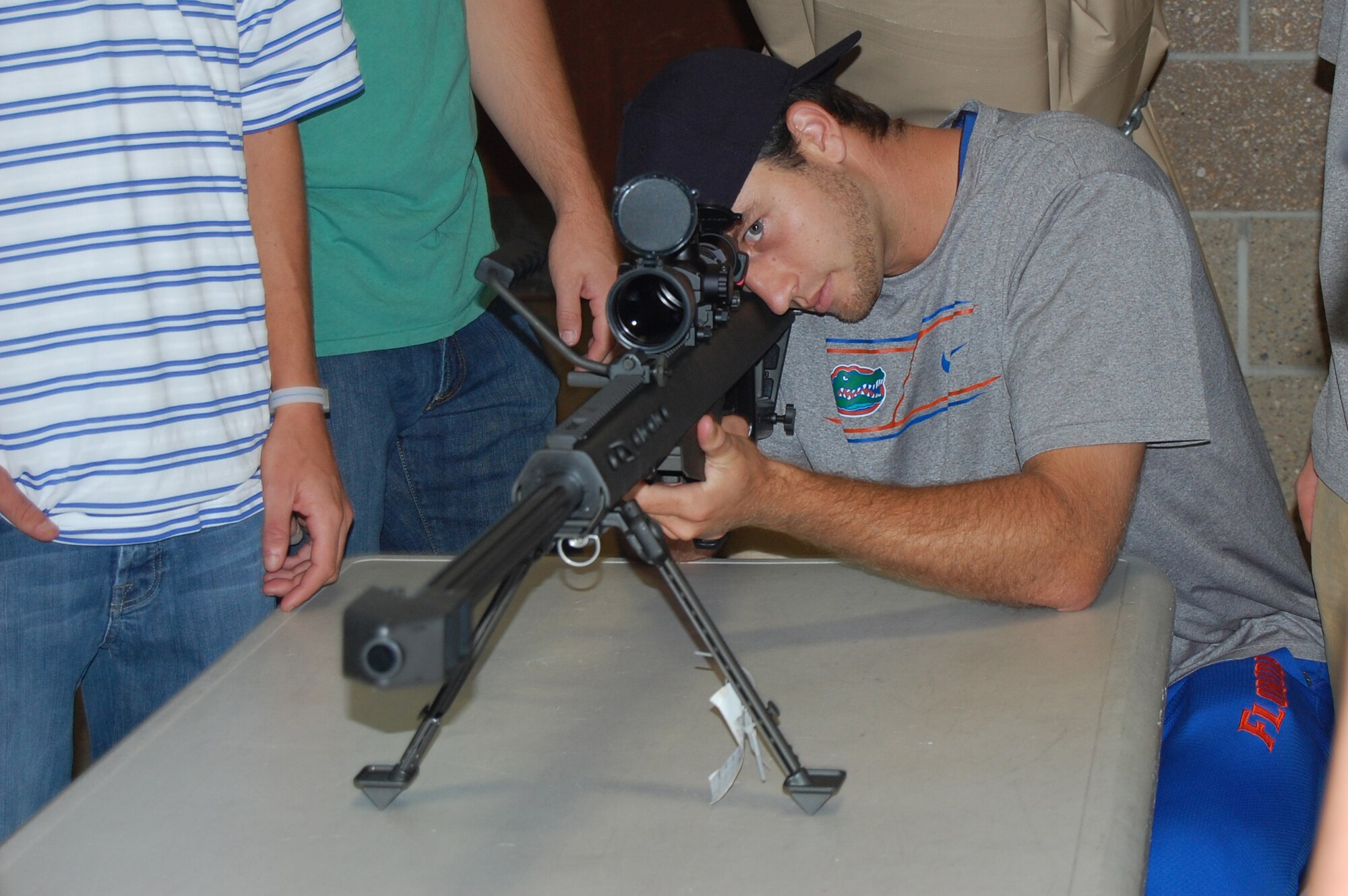OFFUTT AIR FORCE BASE, NE - Members of the Univeristy of Florida Gators baseball team take turns looking through the sights of a sniper rifle during a tour of the 55th Security Forces Squadron armory June 20. As the official sponsor of the Gators for the 2010 College World Series, 55th Wing members treated the team to a base tour, a weapons demonstration and barbecue dinner at the Community Center.  U.S. Air Force photo by 1st Lt. Kenneth Scholz 