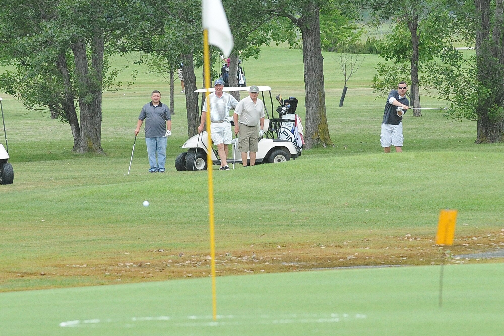 Master Sgt. Steve Sirois, 319th Aircraft Maintenance Squadron, Brian Kraft and Dwayne Loven (left to right) watch as teammate Chief Master Sgt. David Suozzi, 319th AMXS, takes a shot June 21 during the Military Affairs Committee Golf Tournament at Grand Forks Air Force Base, N.D. The MAC Golf Tournament is an annual golf scramble consisting of two tournaments, one on Grand Forks AFB and one in the city of Grand Forks. Each four-man team is made up of both base personnel and members of the Grand Forks community. The event has been taking place since the 1980’s and continues to be a unique way for base and community members to interact. 