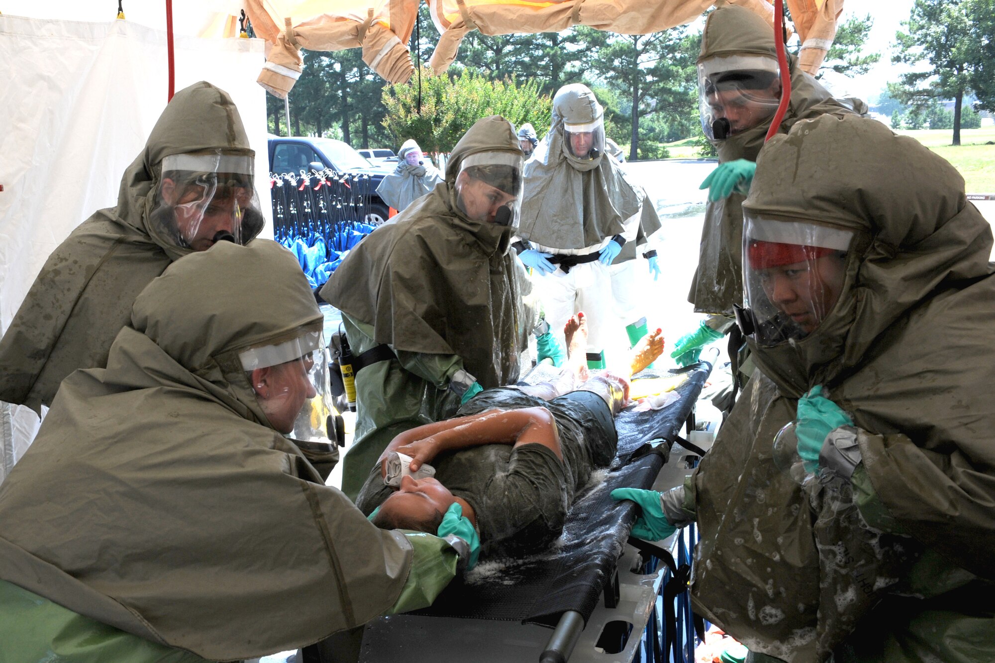 Members of Team Little Rock send a simulated victim of a chemical attack through an in-place patient decontamination wash station June 18 during a base exercise. The in-place patient decontamination has three steps: washing, rinsing and drying the victims, which is the most efficient way of removing chemical traces. (U.S. Air Force photo by Senior Airman Ethan Morgan)