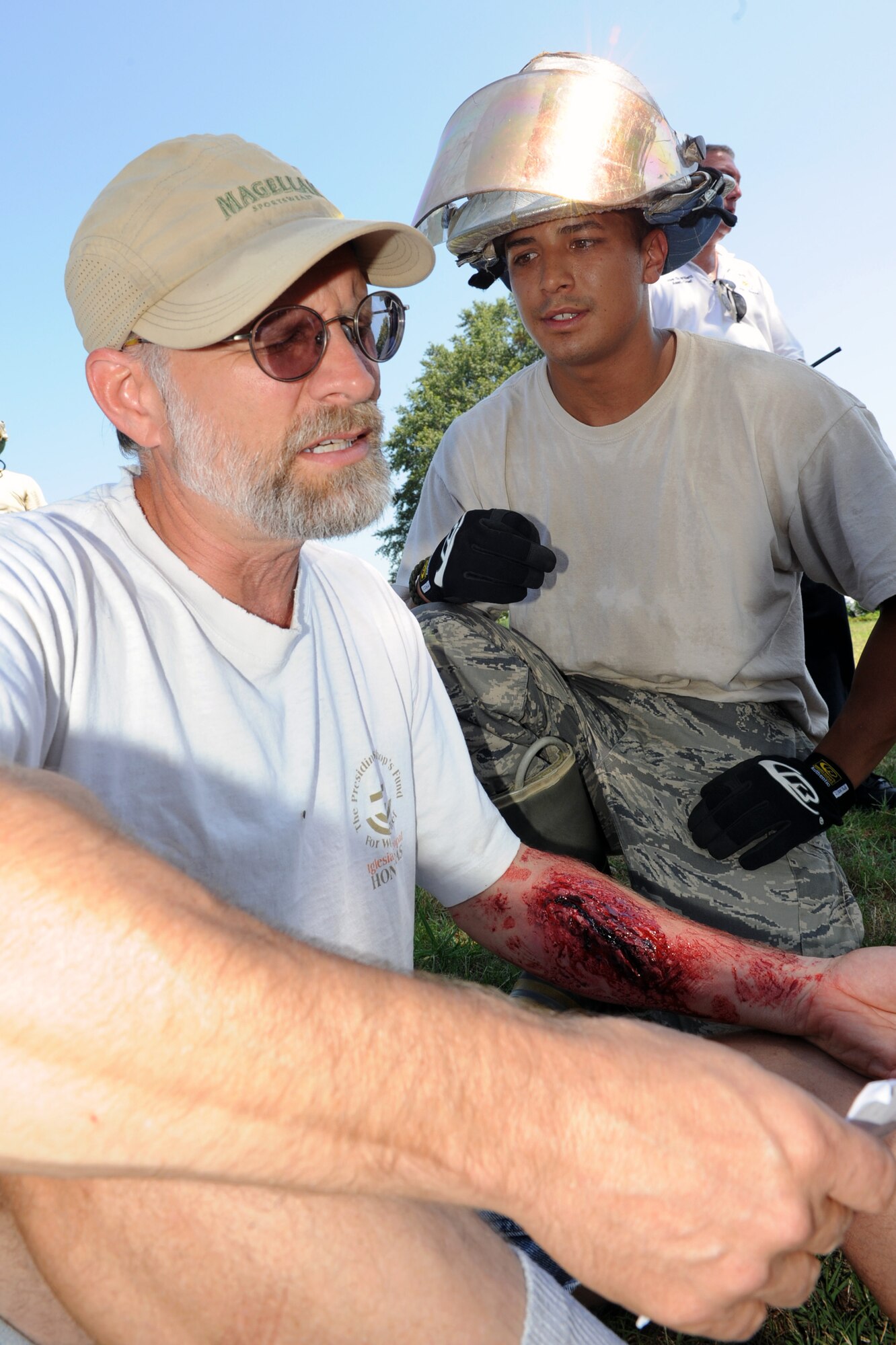 Daniel Yeatts, an exercise volunteer from Summit Church, is checked over by Airman 1st Class Stephen Carey, a 19th Civil Engineer Squadron firefighter, during a 19th Medical Group exercise June 18. About 150 military and civilian volunteers participated in the exercise. (U.S. Air Force photo by Senior Airman Ethan Morgan)