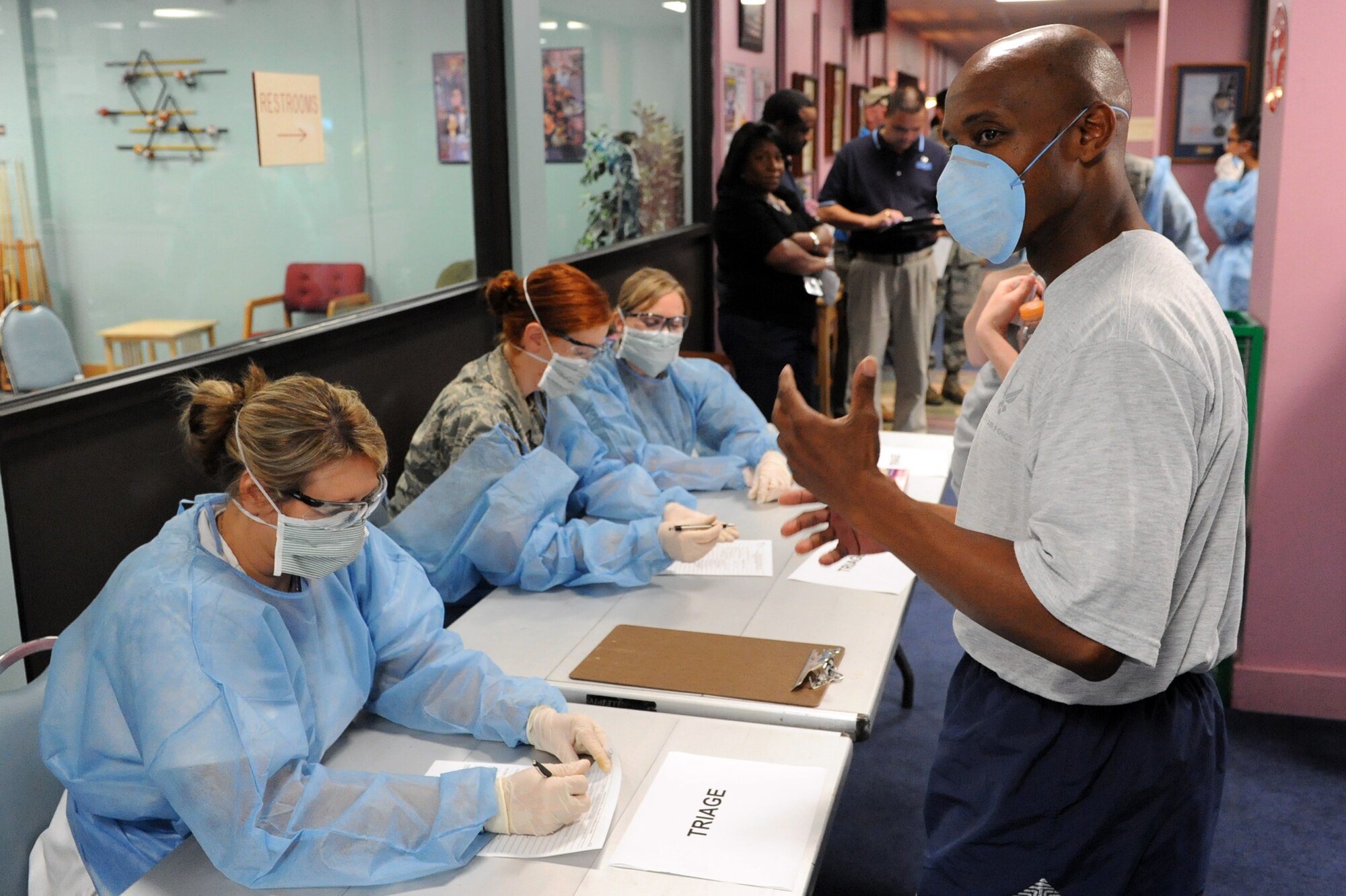 Tech. Sgt. Alfredo White, a 19th Communications Squadron voice systems technician, explains his symptoms to the medical staff June 17 during a 19th Medical Group point-of-dispensing exercise at the Thomas Community Activities Center. The point-of-dispensing stations are designed to protect the health of the installation's population through administration of critical interventions of medications or vaccinations to prevent the development of disease among those who are exposed or potentially exposed to public health threats. (U.S. Air Force photo by Senior Airman Ethan Morgan)