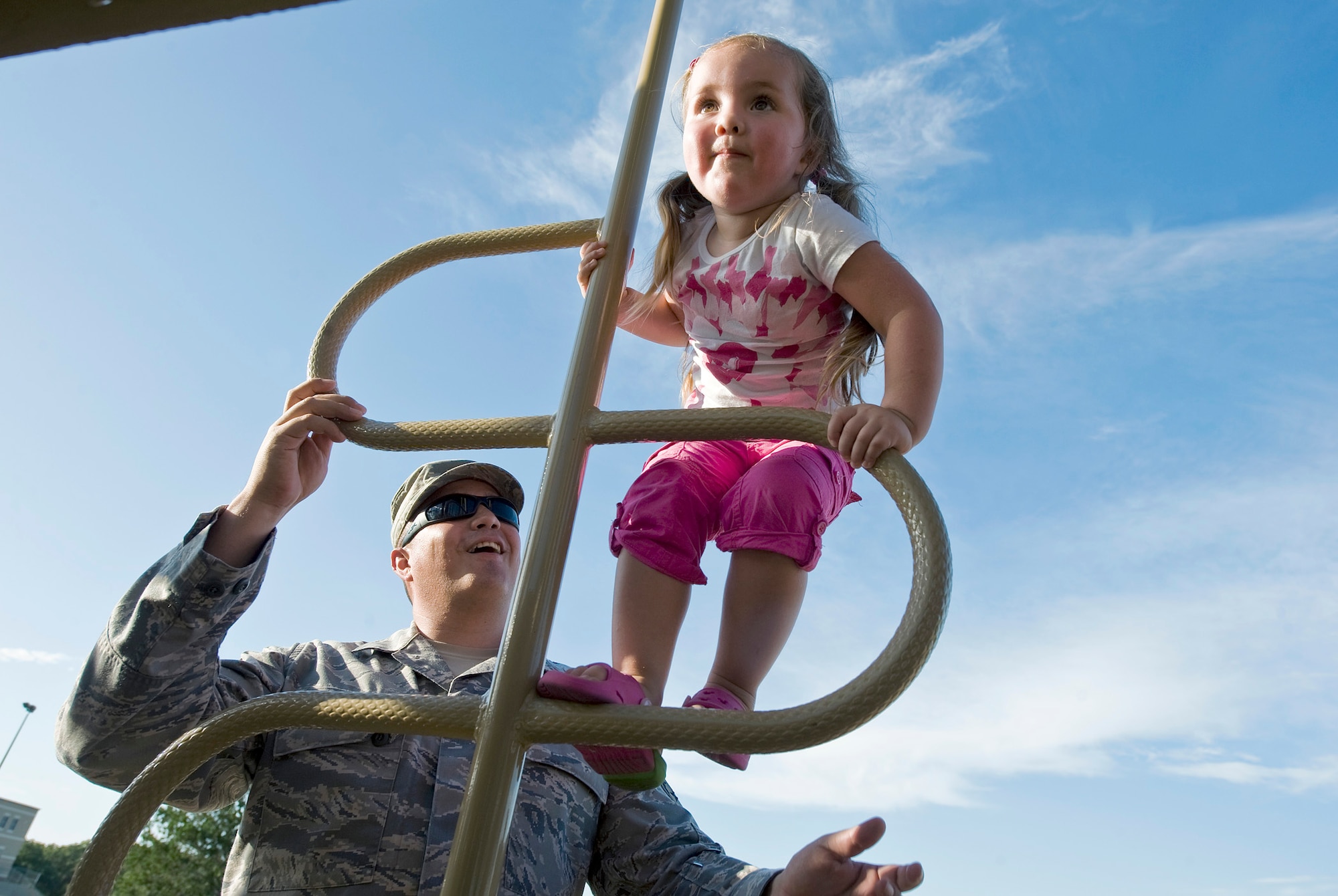 Master Sgt. Rodolfo Gamez watches over his daughter, Eva, while she climbs on a jungle gym at their neighborhood park. The Gamezes are set to deploy to separate locations later this year for year-long deployments. (U.S. Air Force photo/Staff Sgt. Bennie J. Davis III)
