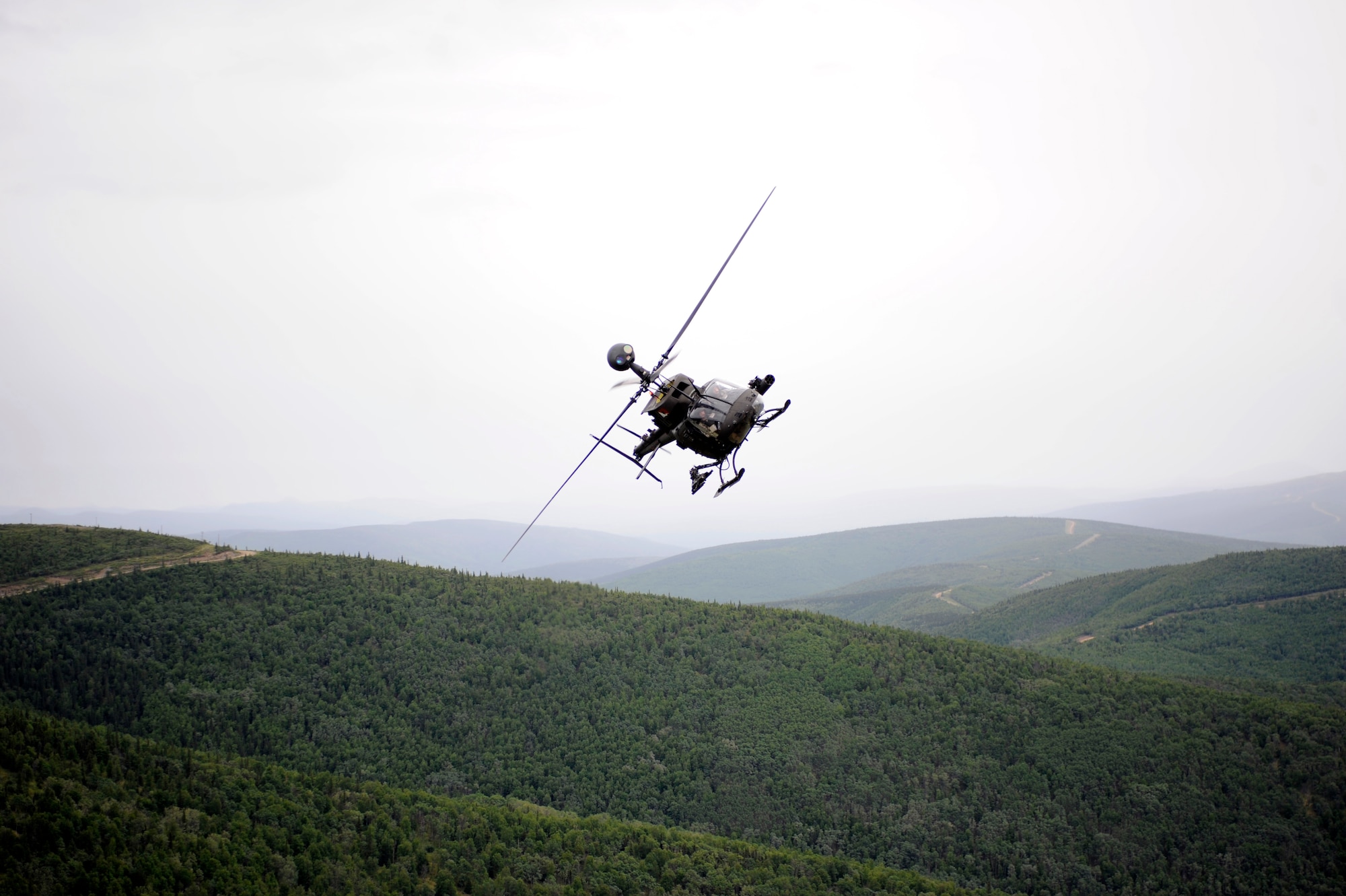 An OH-58 Kiowa flies toward a simulated enemy threat June 17, 2010, Eielson Air Force Base, Alaska. The Kiowa is responsible for observation, utility, and direct fire support, like in this mock extraction of Japanese Air Self Defense Force personnel. The soldiers are assigned to Fort Wainwright, Alaska. (U.S. Air Force photo/ Willard E. Grande II)