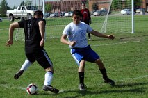 MINOT AIR FORCE BASE, N.D. -- Senior Airman Castro Jorge, 5th Logistics Readiness Squadron traffic management apprentice, challenges the 5th Maintenance Squadron team’s defense here June 15. The 5th MXS team routed the 5th LRS team 2-1. Different squadrons on Minot Air Force Base participate in intramural soccer matches at the field in front of the McAdoo Sports and Fitness Center as a way of increasing unit cohesiveness and boosting base morale. (U.S. Air Force photo by Airman 1st Class Aaron-Forrest Wainwright)