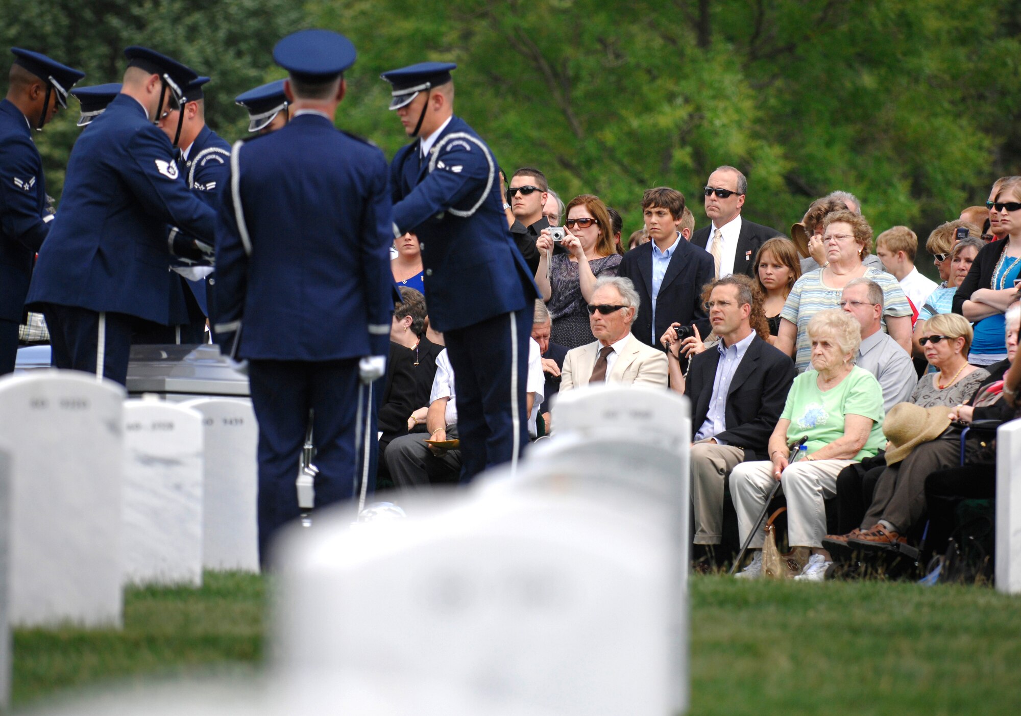 Families observe as an Air Force honor guard folds the flag that draped a casket containing unidentified remains during a burial service at Arlington National Cemetery, June 17, 2010. The ceremony honored 14 airmen who were killed in March 1972 when their aircraft was shot down over southern Laos. (DoD photo/Army Sgt. 1st Class Michael J. Carden)