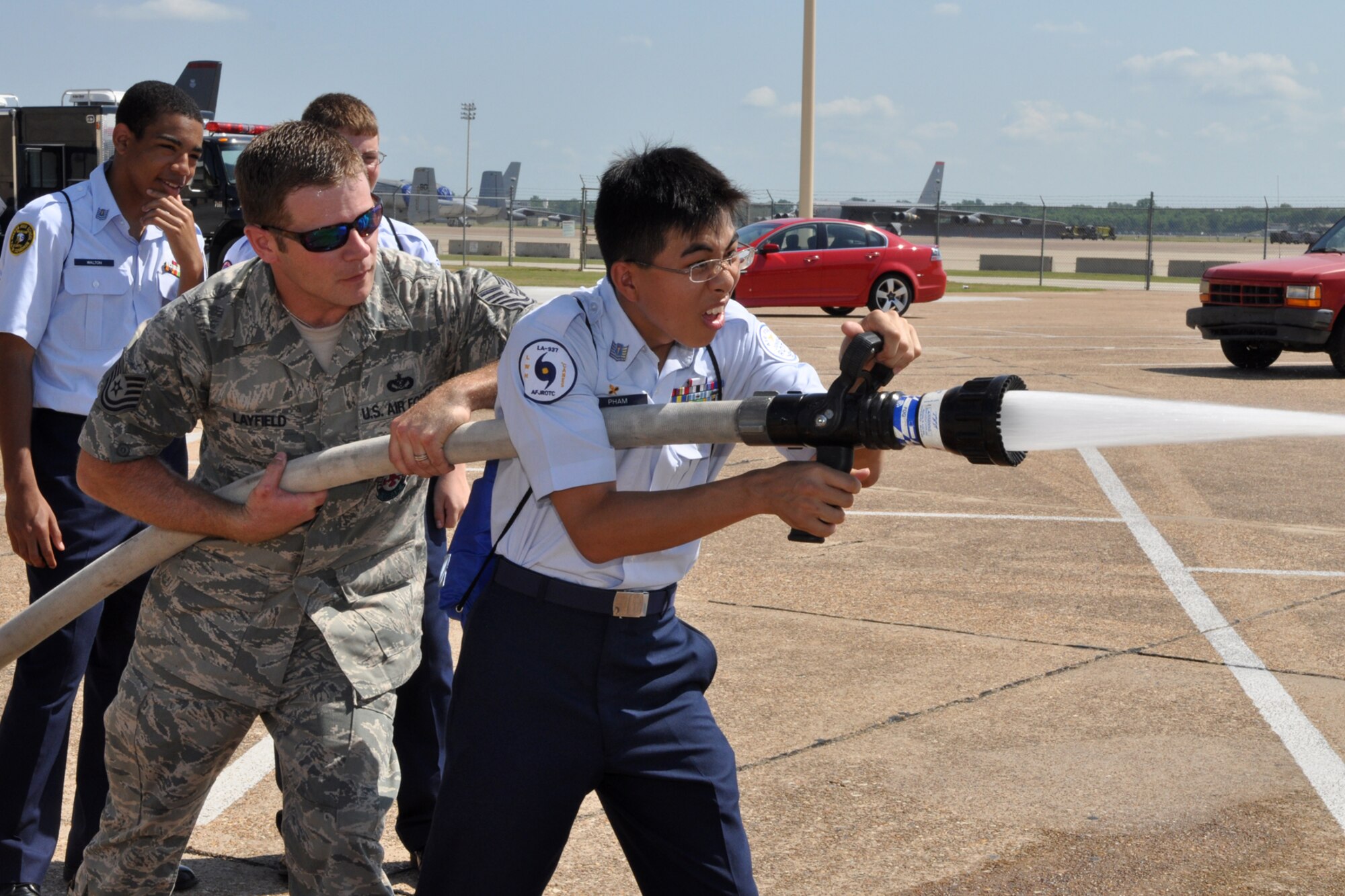 Tech. Sgt. Jason Layfield, fire inspector, 2nd Civil Engineers Squadron, instructs Cadet Thien Pham, from L.W. Higgins High School JROTC in Marrero, La., how to use a fire hose during the JROTC Open House held at Barksdale Air Force Base, La., June 17, 2010. Airmen from over 40 Air Force Specialty Codes (AFSC) at Barksdale were represented during the open house to explain career options to the cadets. An AFSC is an alphanumerical code used by the United States Air Force to identify an Air Force Specialty (AFS) or in layman’s term, a type of job or career field. (U.S. Air Force photo/Tech. Sgt. Jeff Walston)

