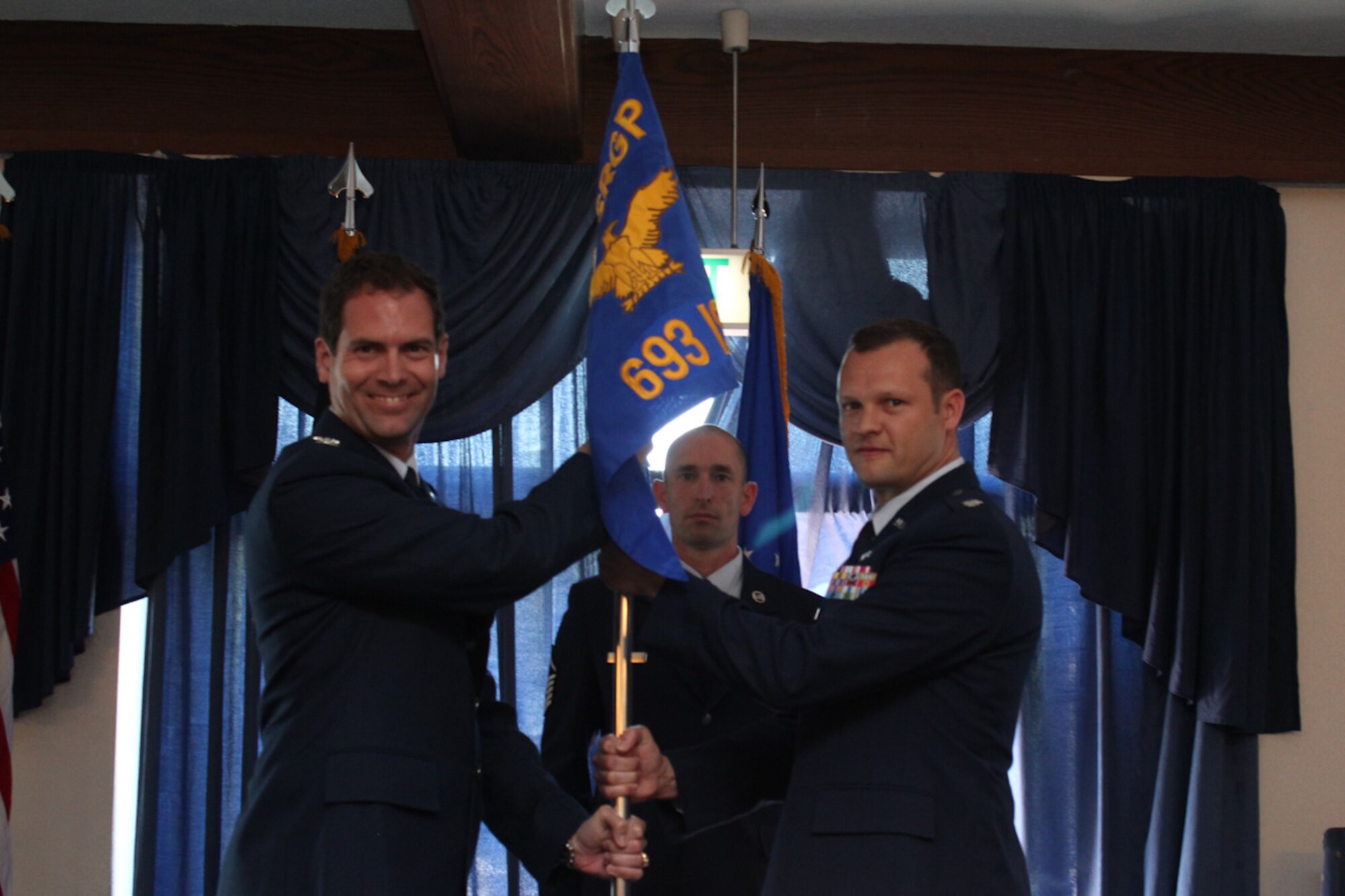 Col. Eric Holdaway, commander of the 693rd Intelligence, Surveillance and Reconnaissance Group, Ramstein Air Base, Germany, passes the guidon to Lt. Col. Jason Winslow, the commander of the newly activated 693rd Intelligence Support Squadron during an activation ceremony June 3. The activation of the new squadron is the latest step in standardizing the Air Force Distributed Common Ground System. (U.S. Air Force courtesy photo)