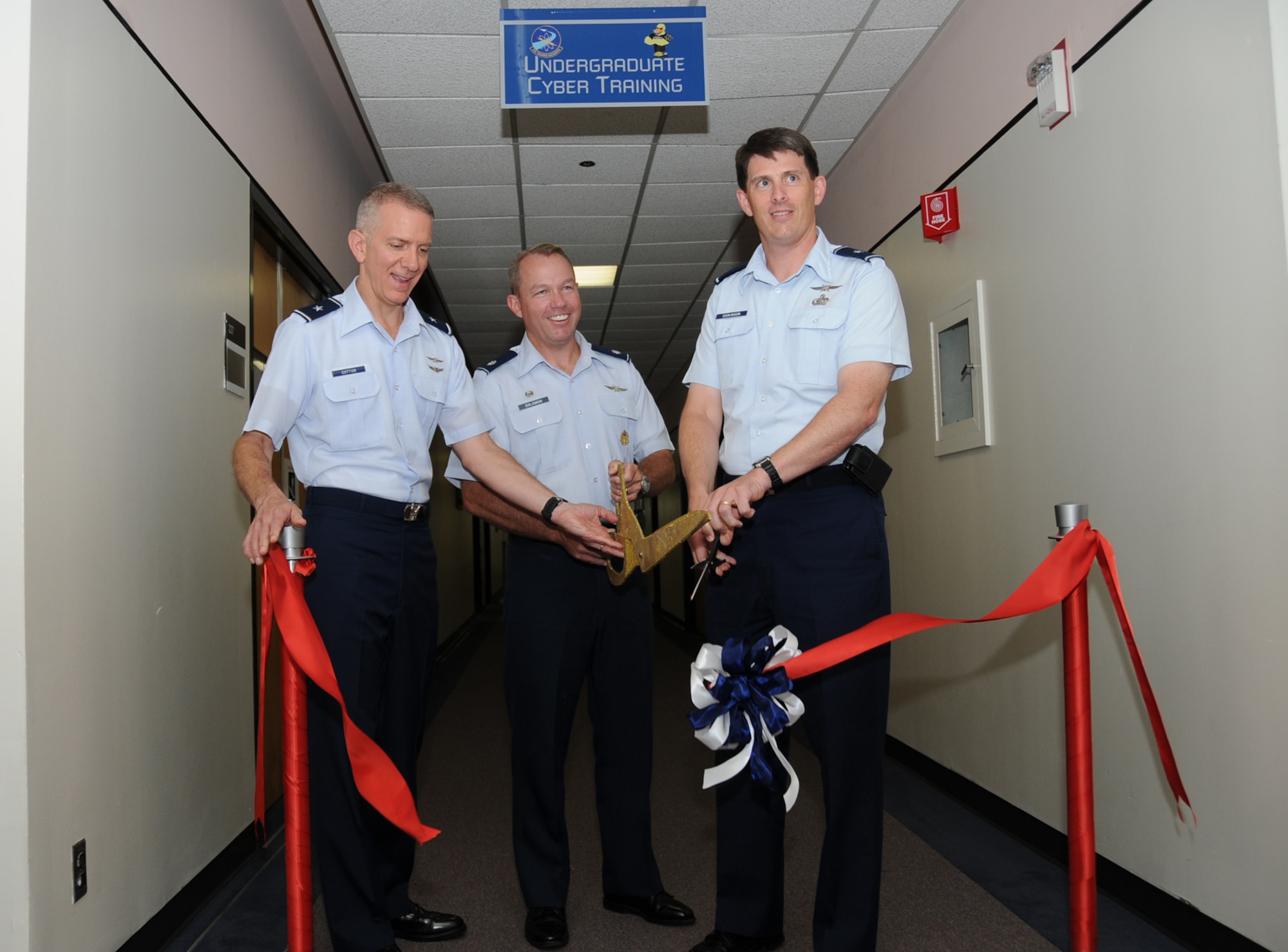 From left, Brig. Gen. David Cotton, Lt. Col. Scott Solomon and Brig. Gen. Ian Dickinson cut the ribbon of Keesler's undergraduate cyber training schoolhouse Monday at Stennis Hall.  General Cotton is the Director of Cyberspace Operations, Office of Information Dominance and Chief Information Officer.  Colonel Solomon is commander of the 333rd Training Squadron, where the first 16 officers began training Tuesday.  General Dickinson is commander of the 81st Training Wing.  Up to 400 military members, civilians and international students are expected to complete the course each year.(U.S. Air Force photo by Kemberly Groue)