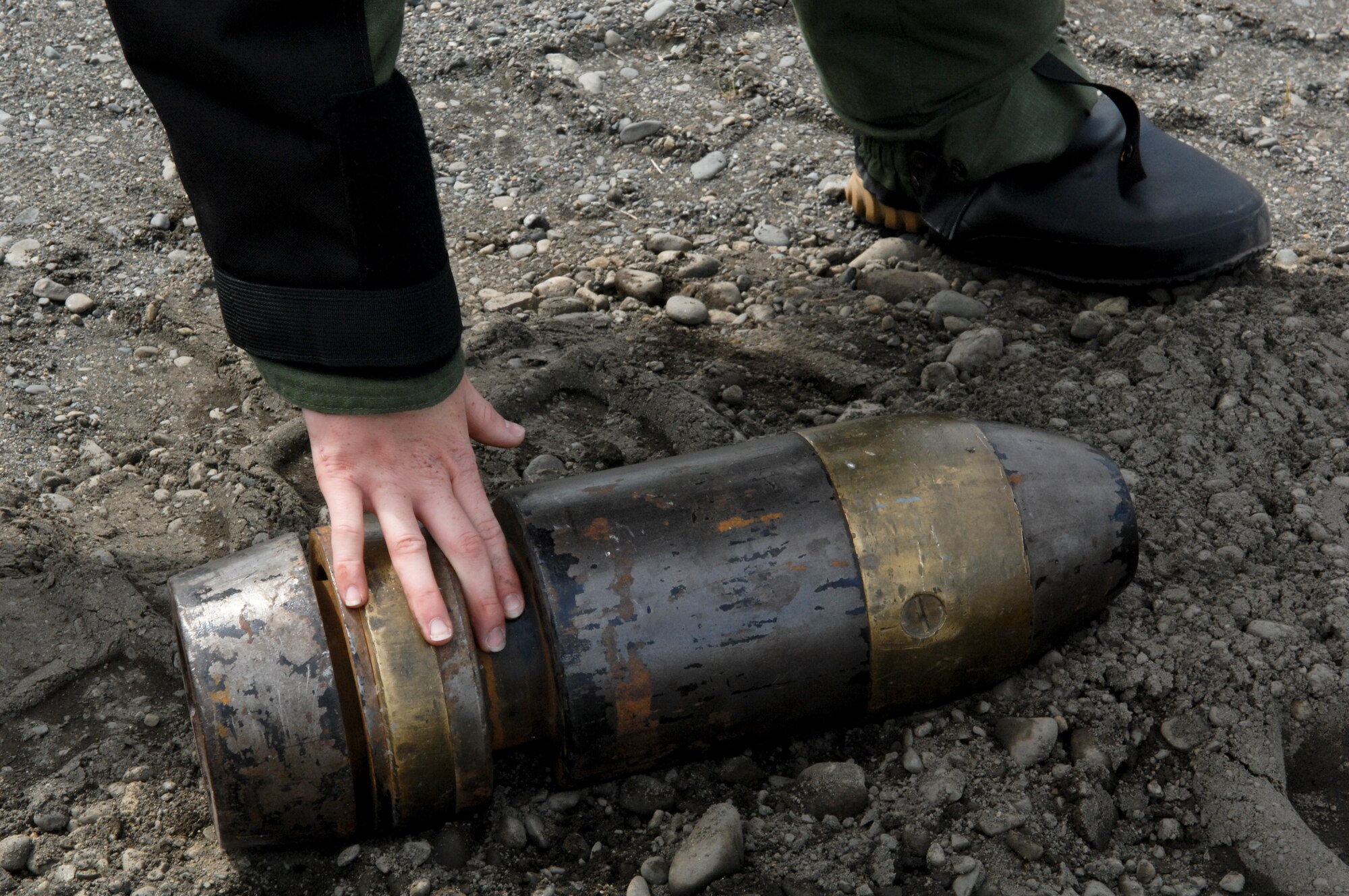 A 75-pound simulated explosive ordinance lays on the ground as Airman 1st Class Monica Benzien, 3rd Civil Engineer Squadron explosive ordinance disposal journeyman, prepares to move the object during a weekly training exercise June 17. EOD members train weekly on proper disposal of ordinance. (Air Force photo by Airman 1st Class Jack Sanders)