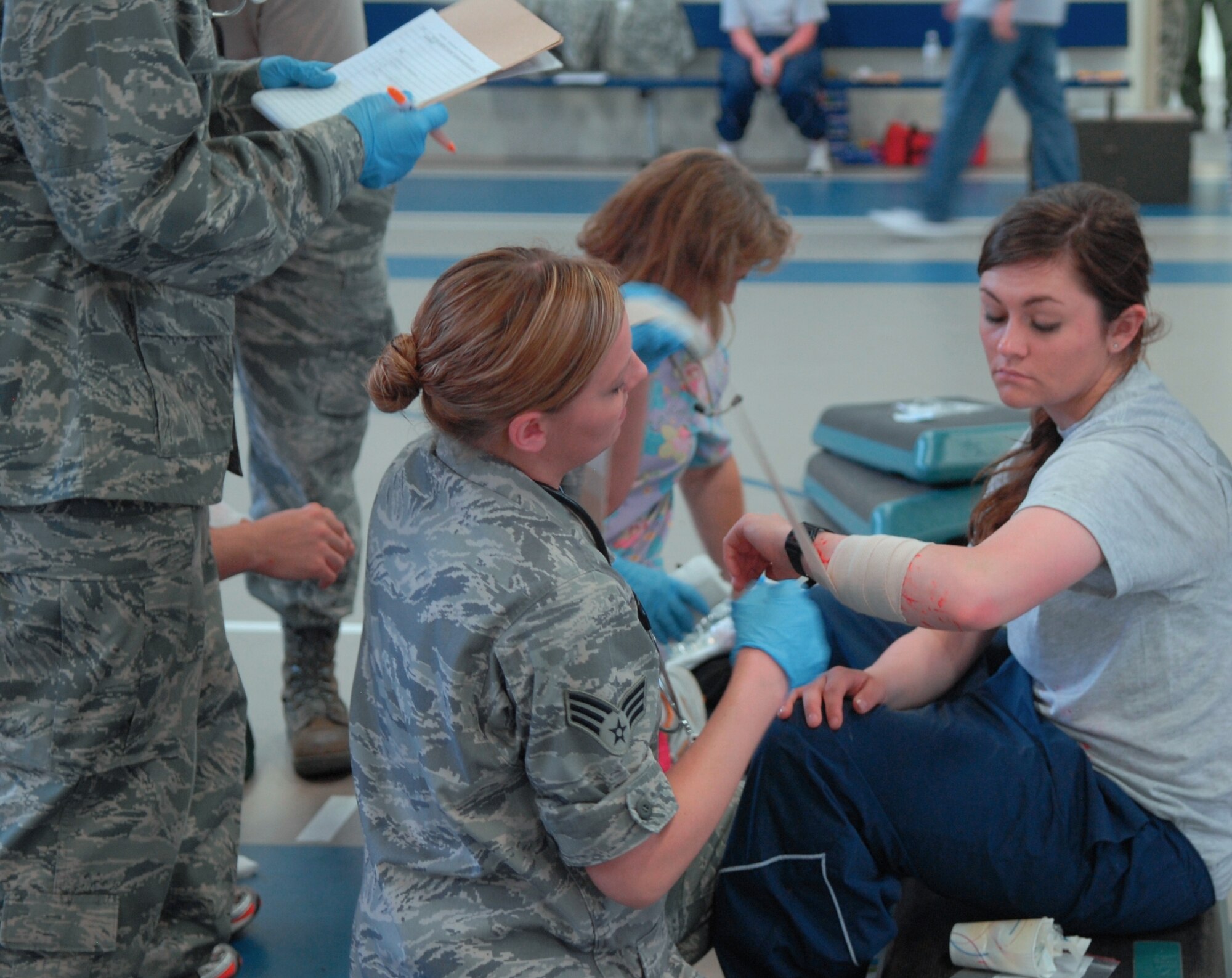 Airmen from the 17th Medical Group help the wounded at their alternate medical facility during a wing-wide natural disaster exercise June 17. A simulated tornado landing at the clinic left medical personel to relocate and get their AMF to operational status to treat those moulaged with cuts and bruises. (U.S. Air Force photo/Lou Czarnecki)
