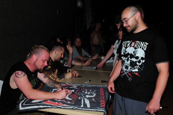 SPANGDAHLEM AIR BASE, Germany -- Ivan Moody, lead singer for Five Finger Death Punch, signs a poster for Tech. Sgt. John Getko from Peterson Air Force Base, Colo. The heavy metal band played a free show for about 500 military members, friends and family at Spangdahlem Air Base’s Skelton Memorial Fitness Center June 10, just days after playing at Rock am Ring, one of Germany’s largest music festivals. (U.S. Air Force photo/Staff Sgt. Heather Norris)