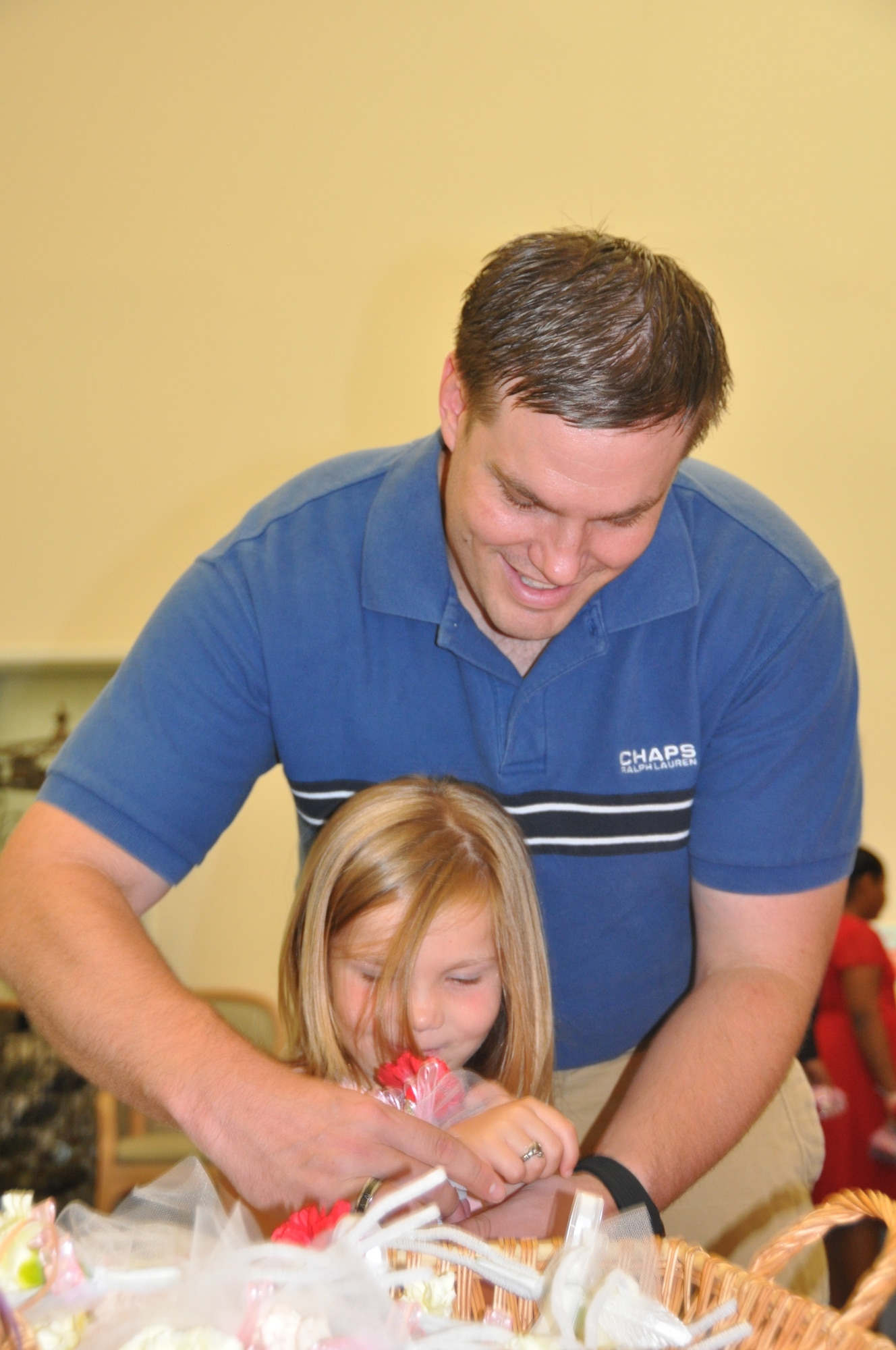 Staff Sgt. Steve Easter, 325th Fighter Wing Equal Opportunities specialist, puts a corsage on his six-year-old daughter Lily’s wrist during the Daddy Daughter Dance June 17.  (U.S. Air Force photo/Senior Airman Veronica McMahon)