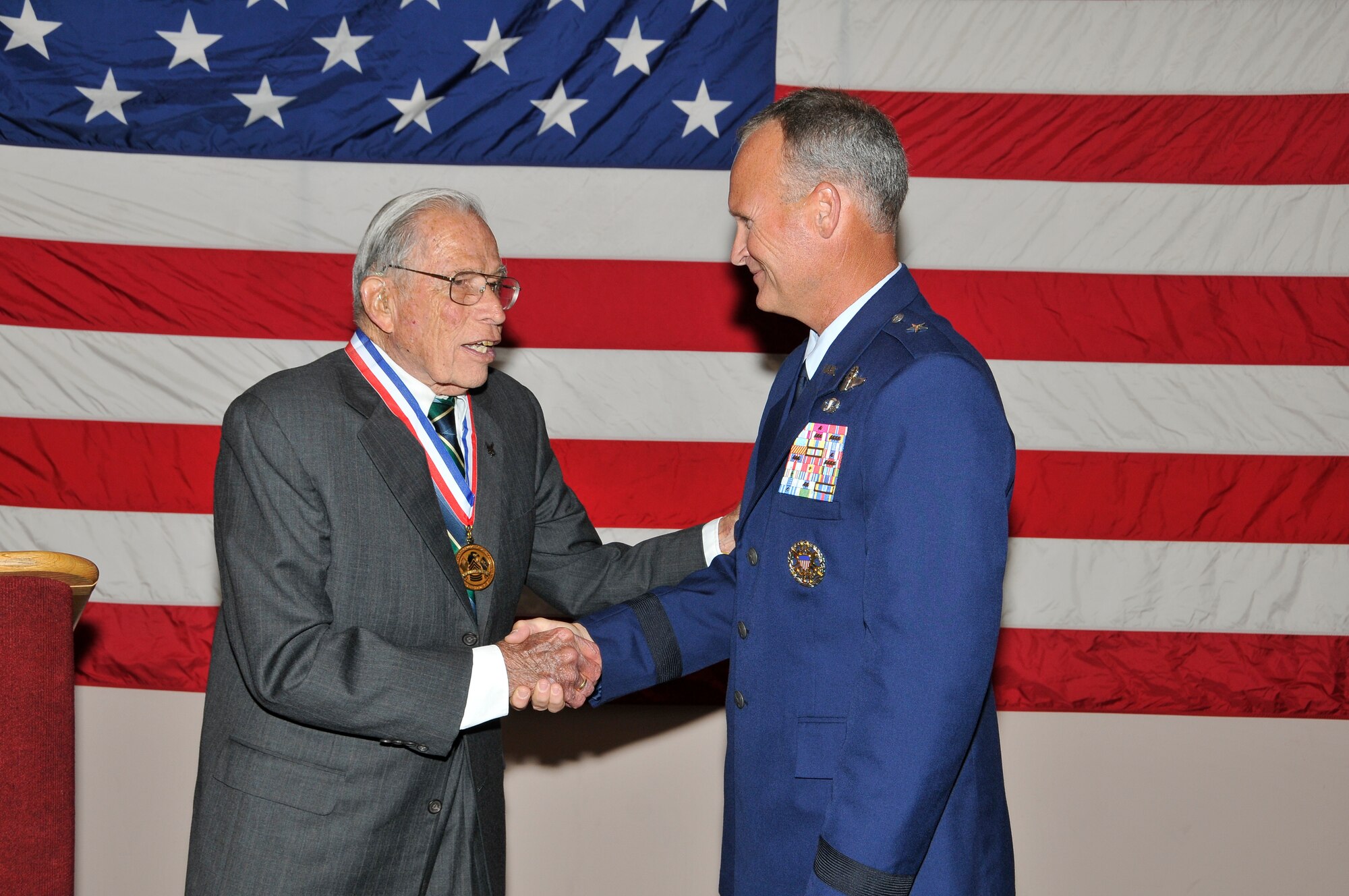 Brig. Gen. James Browne, 325th Fighter Wing commander, presents Mr. John Donnell the Noncommissioned Officers' Association World War II Veterans Medallion during his promotion ceremony at Tyndall’s Heritage Club June 4. (U.S. Air Force photo by Lisa Norman)