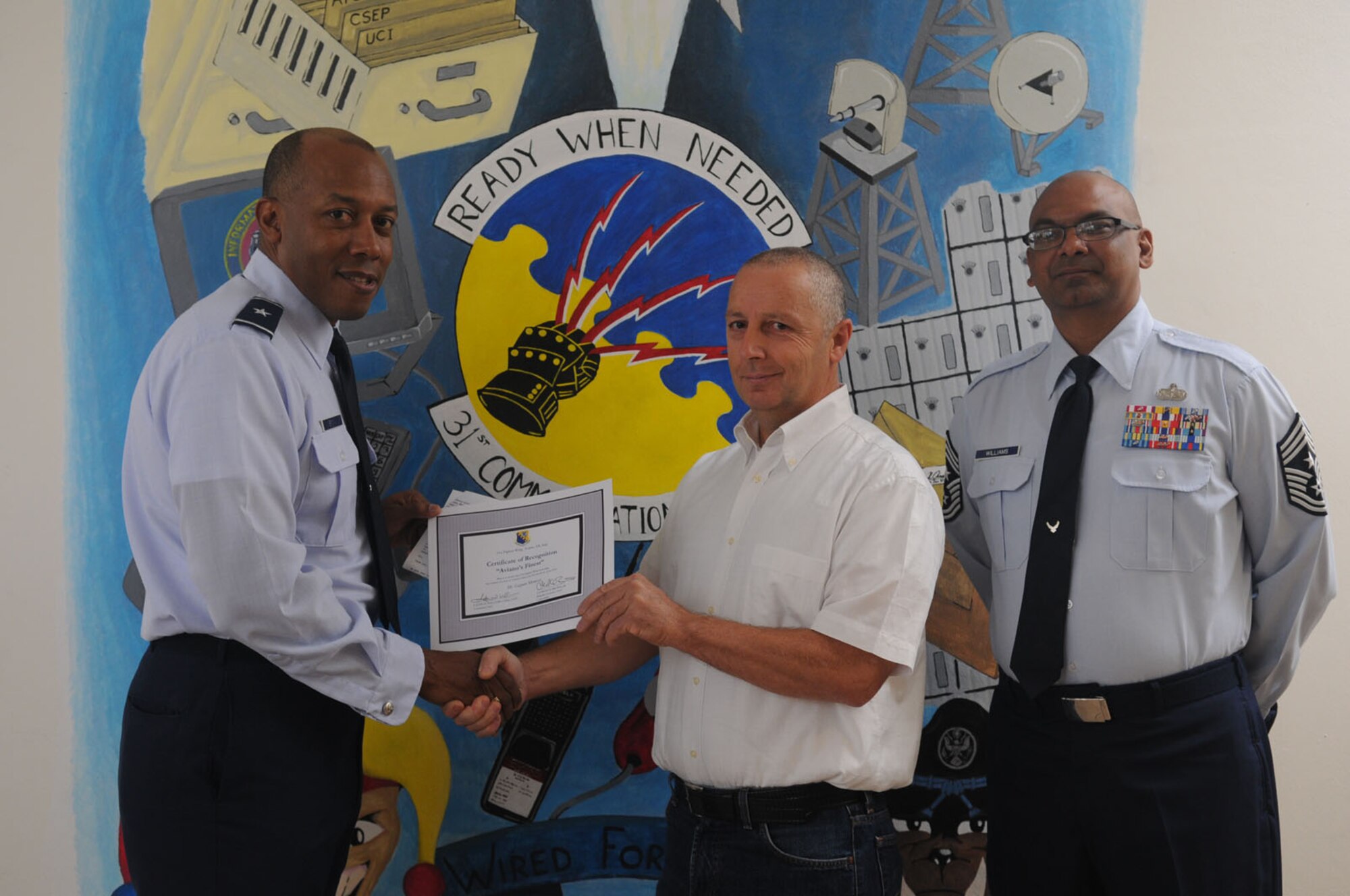 Brig. Gen. C.Q. Brown Jr., 31st Fighter Wing commander, congratulates Mr. Gasper Momesso, 31st Communications Squadron,on his selection as one of Aviano's Finest as Chief Master Sgt. Laten Williams, 31st FW command chief, looks on. (U.S. Air Force photo/ Staff Sgt. Nadine Y. Barclay)