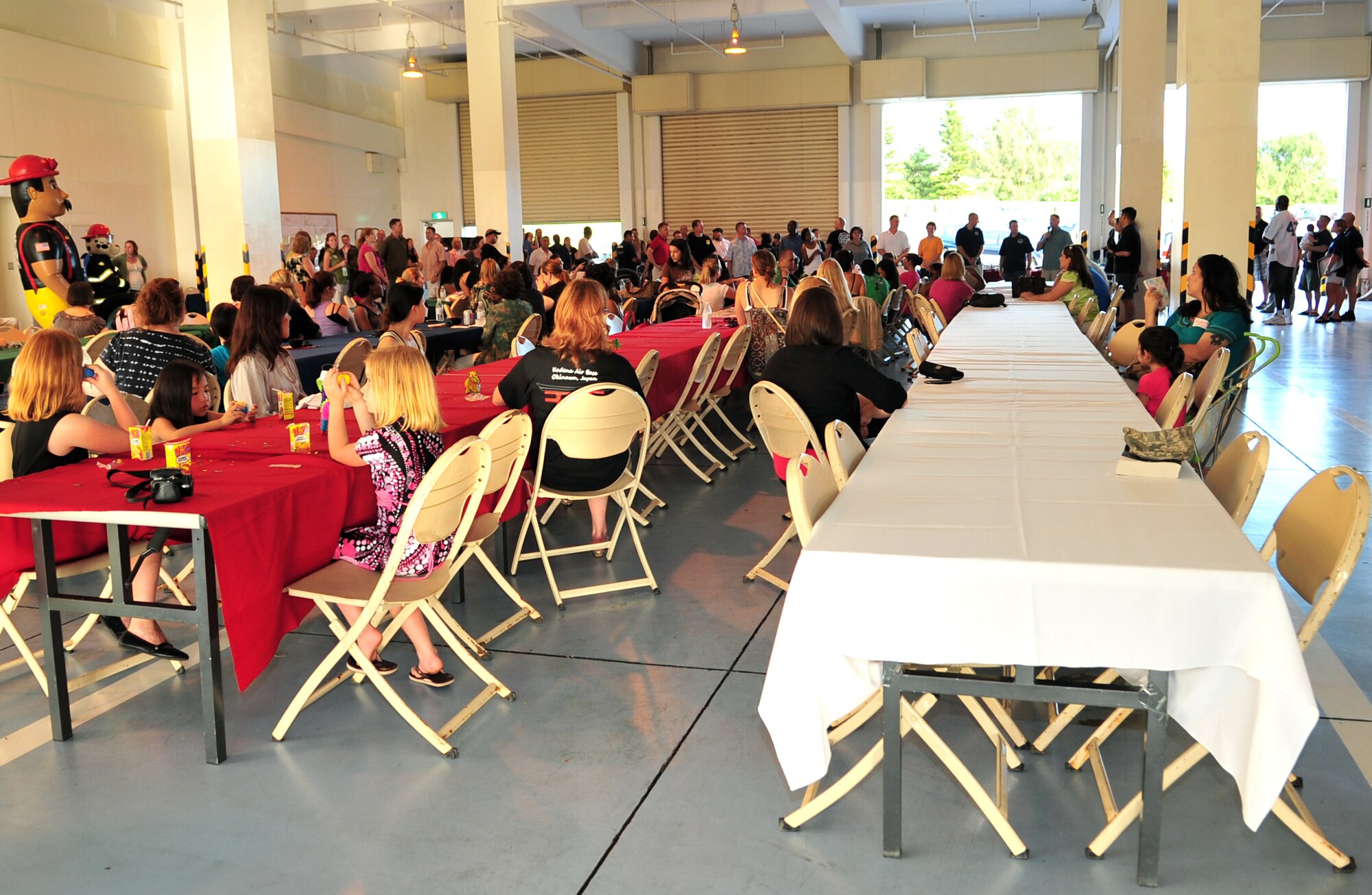 Spouses of deployed servicemembers gather at the Fire Department Headquarters for an evening of food, fellowship, and fun during the Deployed Spouses Dinner, Kadena Air Base, Japan, June 19. More than 90 spouses and 58 children attended the dinner hosted by the 18th Civil Engineer Group.   (U.S. Air Force photo/Tech. Sgt. Rey Ramon)  