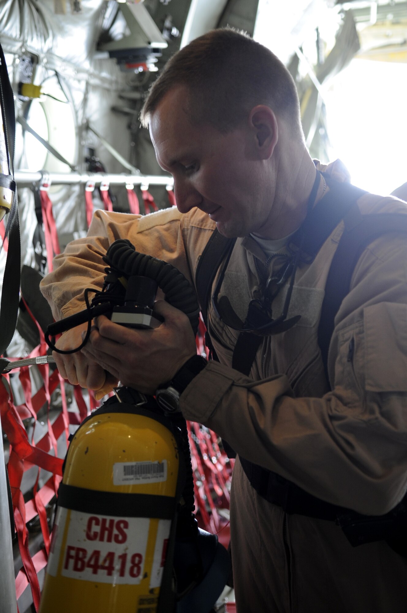 Maj. David Bailey refills an emergency oxygen tank prior to take off on an aeromedical evacuation mission June 9. (U.S. Air Force photo by Senior Airman Nancy Hooks/Released)