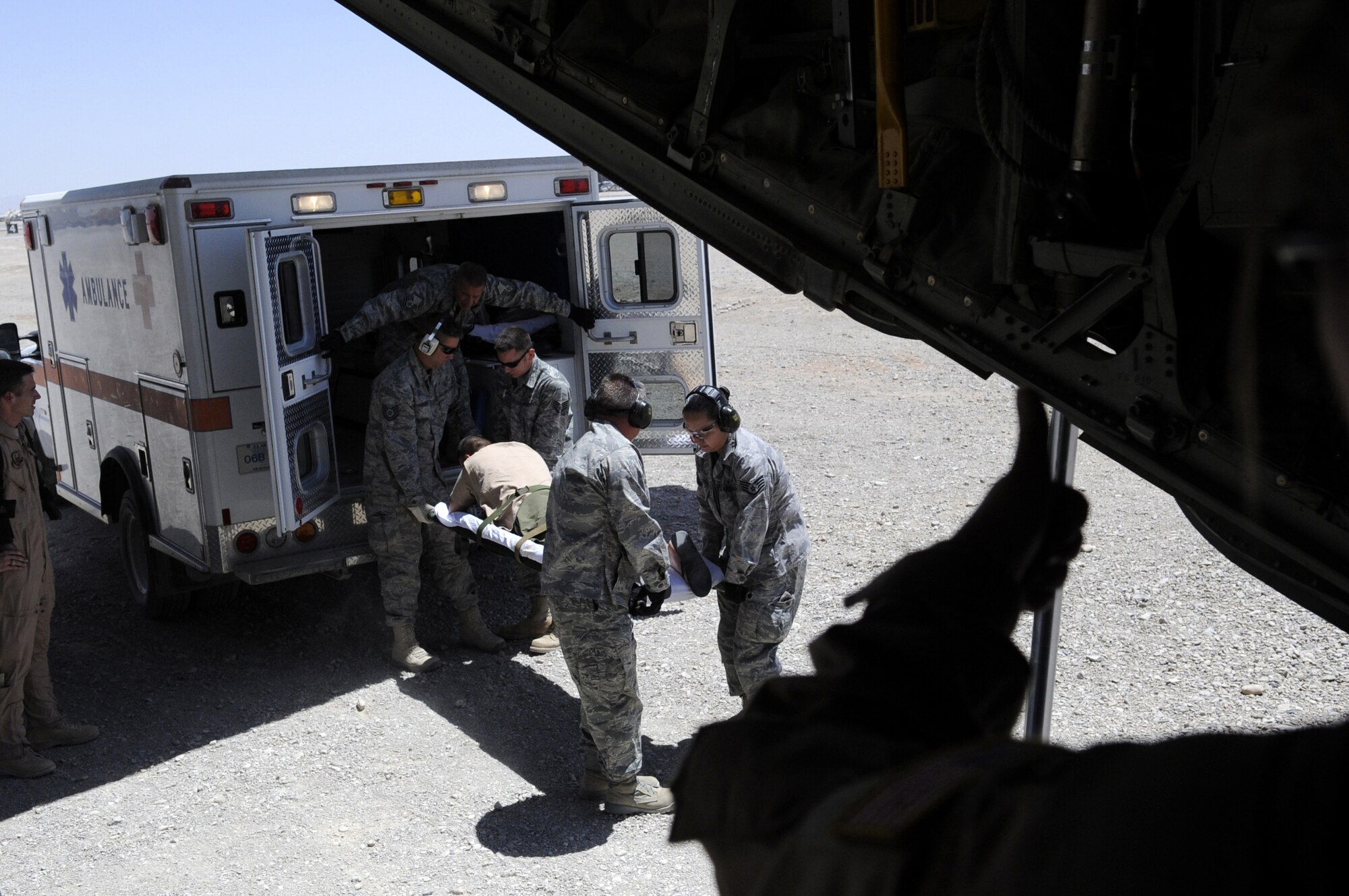 Members of the 451st Expeditionary Aeromedical Evacuation Squadron help load a litter patient onto a C-130J Hercules June 9 from Camp Bastion, Afghanistan, during a Bandage Mission.  Bandage Missions travel to different bases throughout Afghanistan and pick up patients and transport them to a higher level of care.  (U.S. Air Force photo by Senior Airman Nancy Hooks/Released)