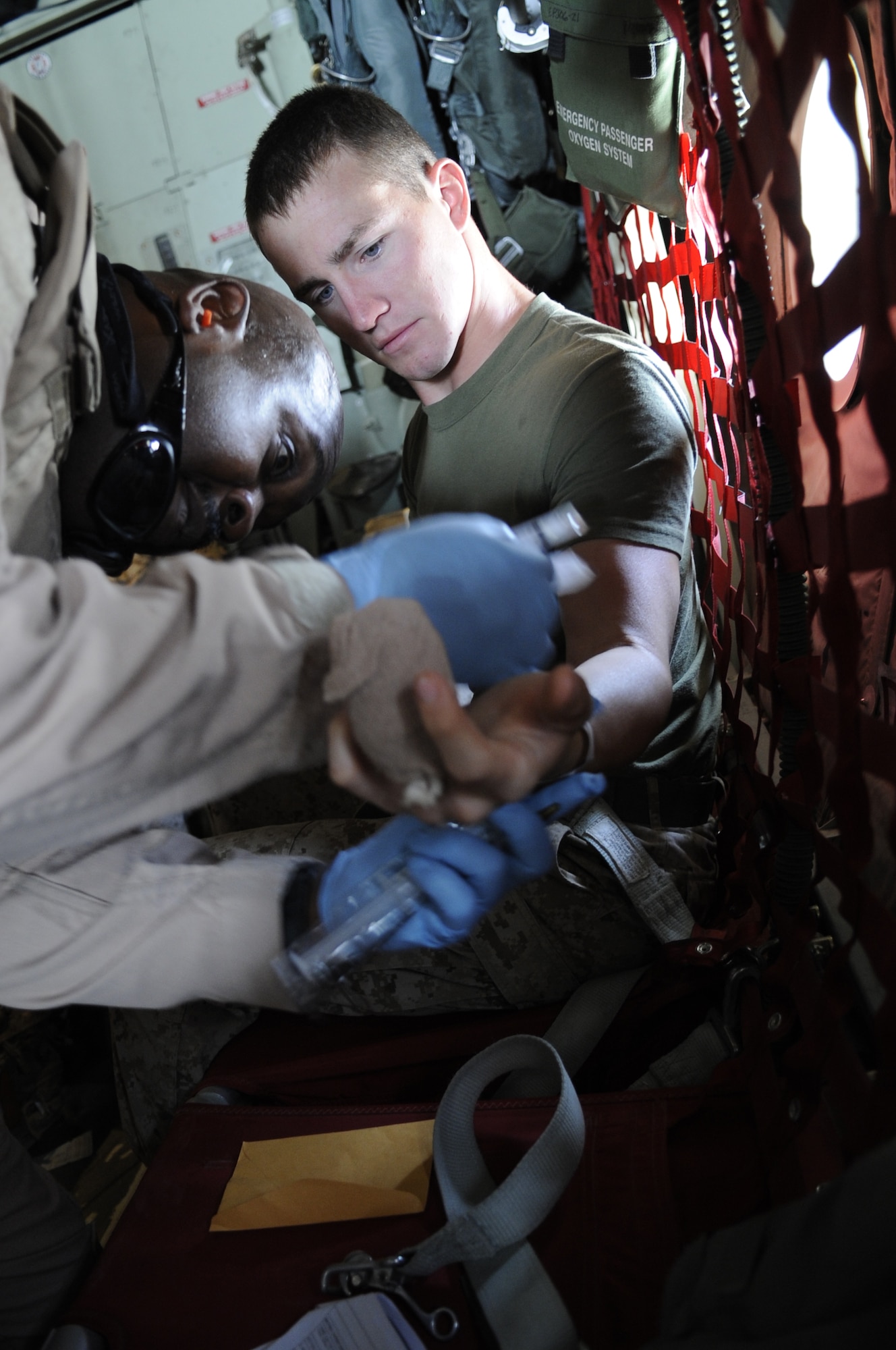 Staff Sgt. Anthony Green, 451st Expeditionary Aeromedical Evacuation Squadron technician, gives Marine Lance Cpl. Joshua Foster, an ambulatory pa-tient, a shot to relieve the pain from his injuries June 9 on a C-130J Hercules. Lance Corporal Foster suffered injuries to his fingers during a work incident at a forward operating base in Afghanistan June 8. (U.S. Air Force photo by Senior Airman Nancy Hooks/Released)